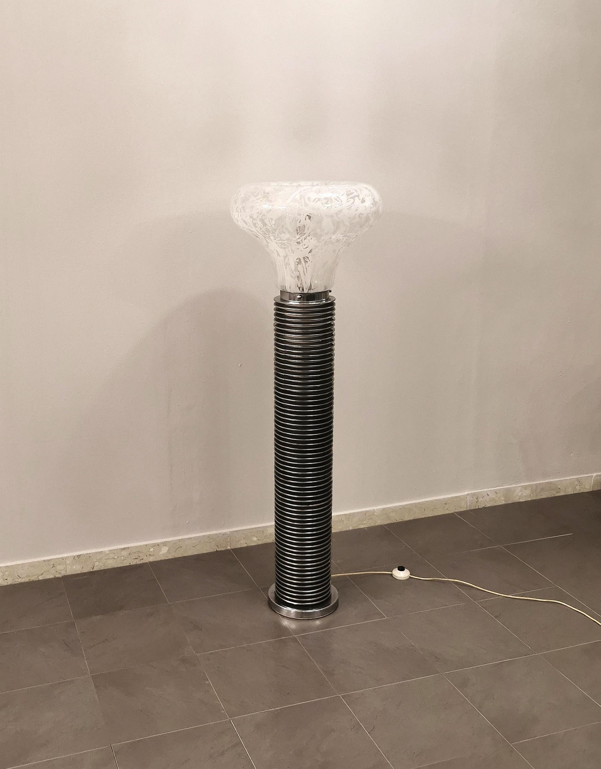 Particular floor lamp with 1 light E27 designed by the Italian designer Carlo Nason and produced by the Venetian glassmaker Mazzega, in the 70s. The lamp has a chromed metal structure made up of 63 round rings with a white and transparent Murano