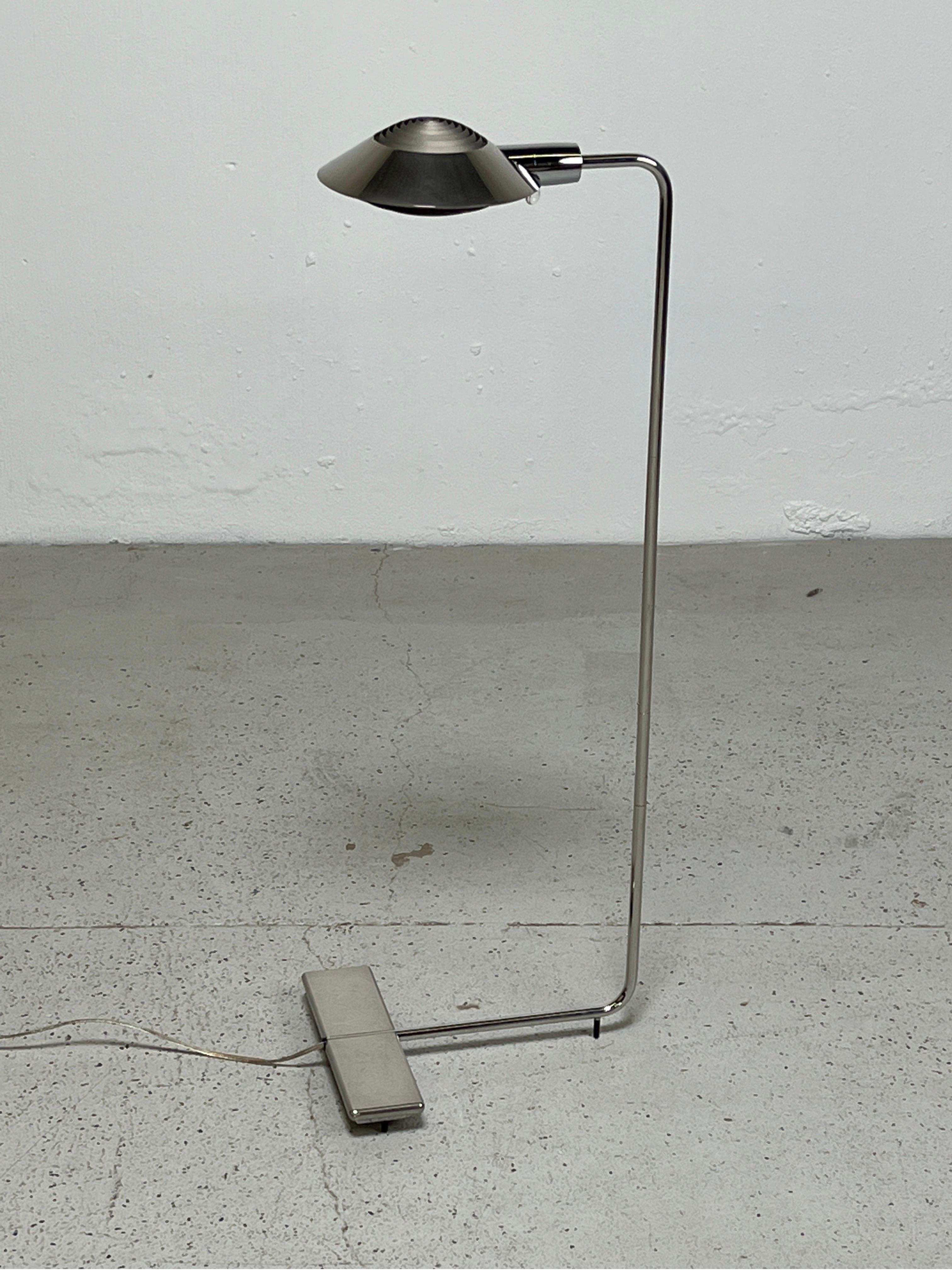A chrome floor lamp designed by Cedric Hartman. Adjustable height and swivel but the hood does not rotate.