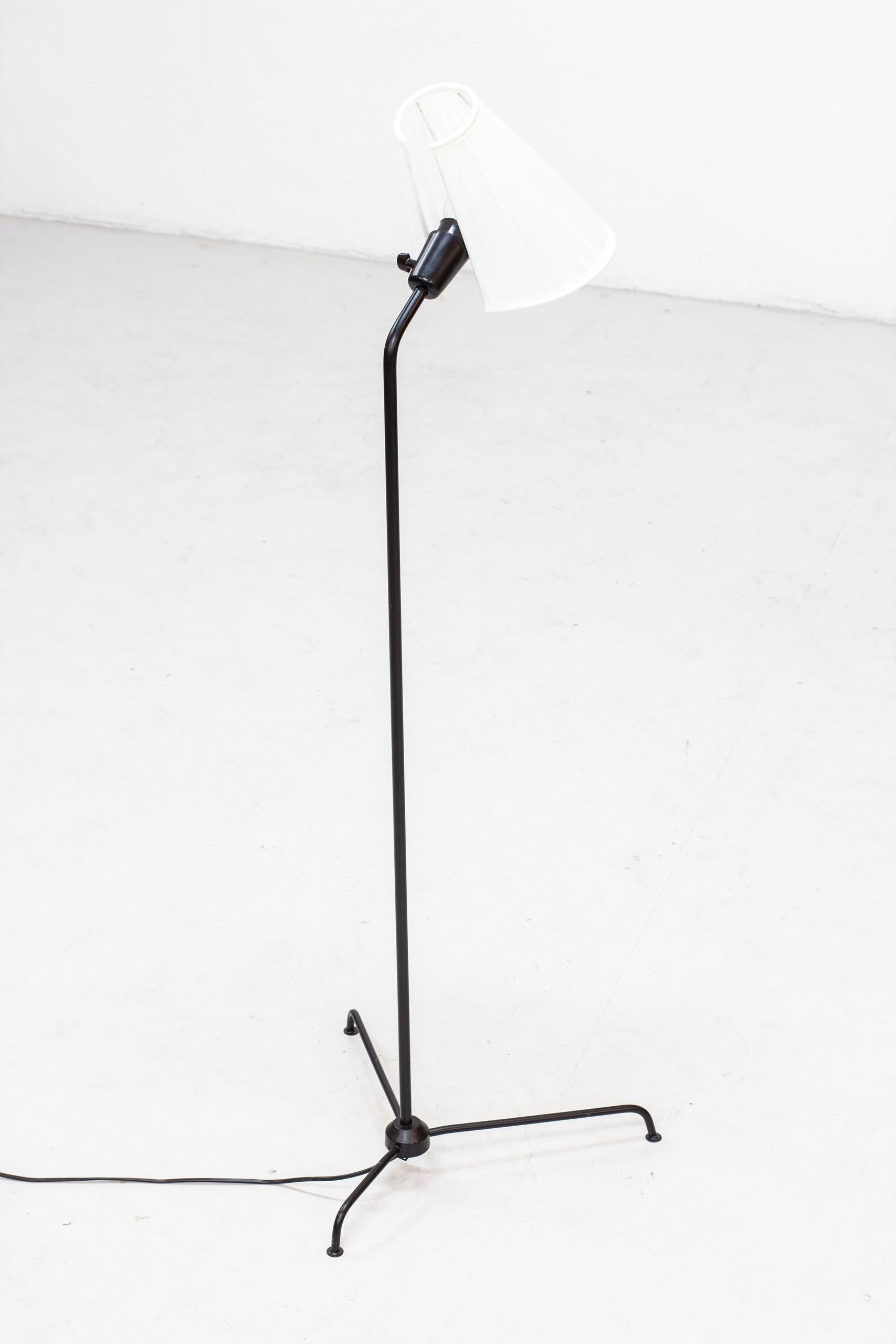 Floor lamp designed by Eje Ahlgren produced in Sweden by Luco during the 1950s. Made from black lacquered metal with original lamp shade reupholstered in white chintz fabric. Original light switch on the lamp fixture in working order. Very good