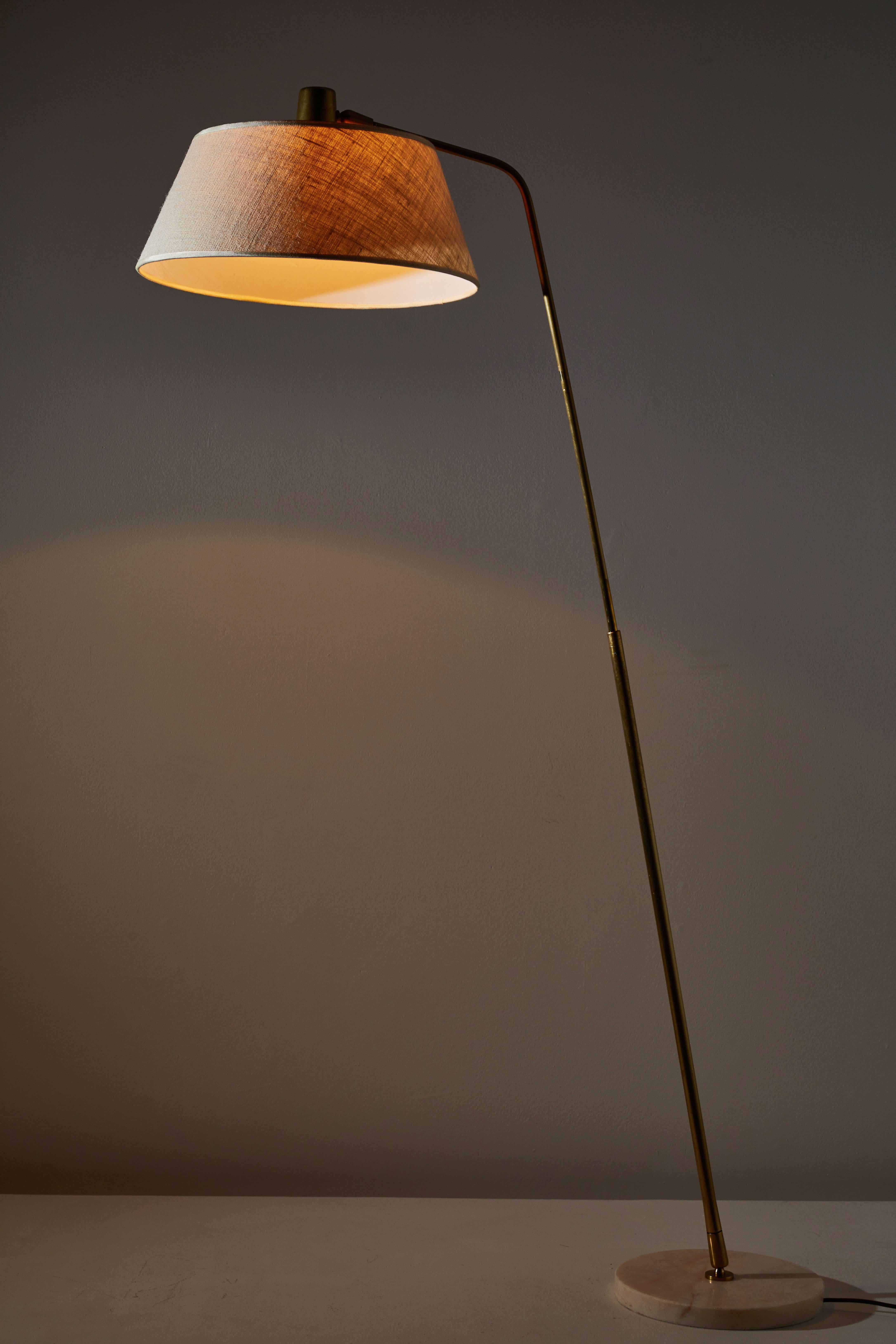Floor lamp by Giuseppi Ostuni for Oluce. Designed and manufactured in Italy, circa 1950s. Brass, marble with custom linen shade. Stem adjust to various angles. Original cord with step switch. Takes on E27 75W maximum bulb.