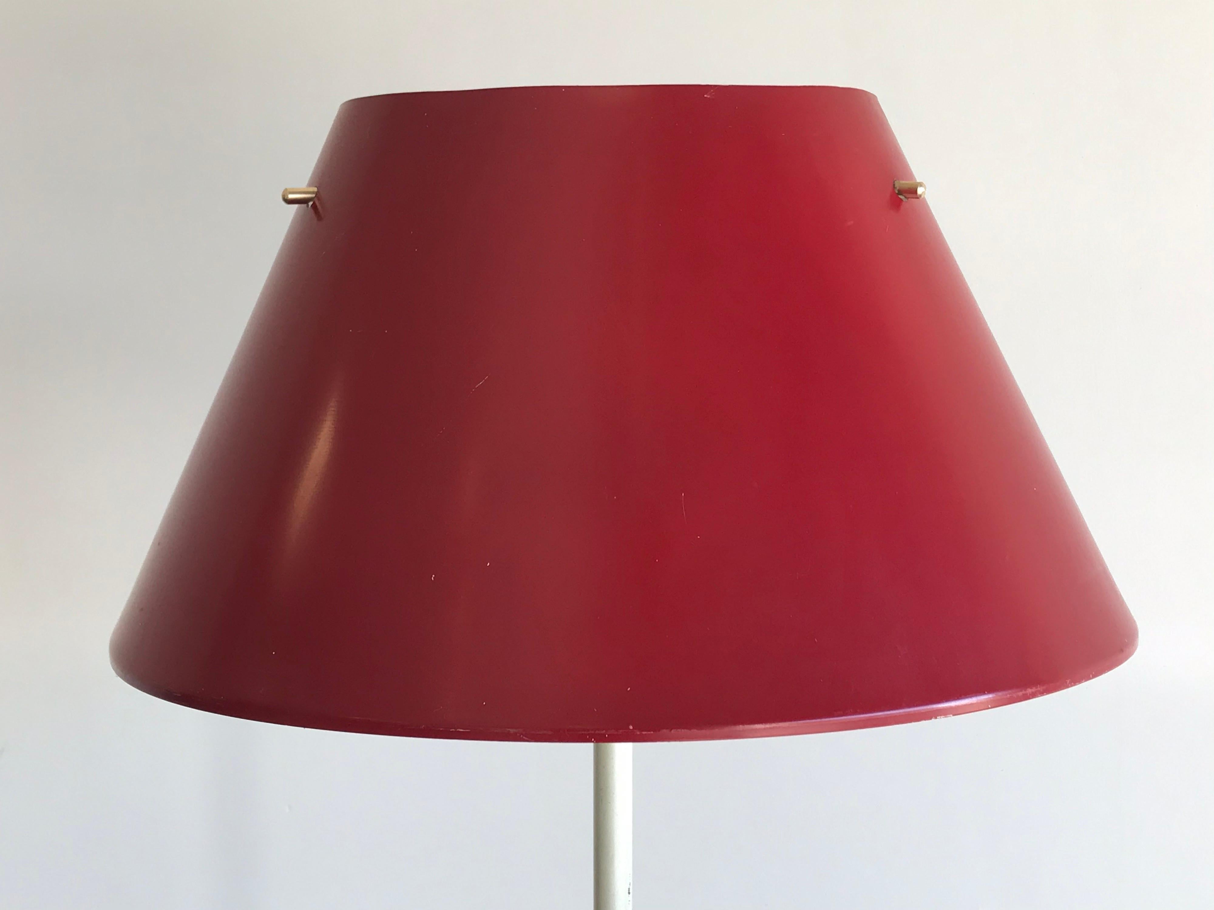 Minimalist floor lamp designed by Hans Agne Jakobsson for Markaryd. Heavy weighted base in white enamel. Floating red enamel shade is supported by three brass pins. Signed both underneath the base and in the shade. 

Wired for US. Takes a standard