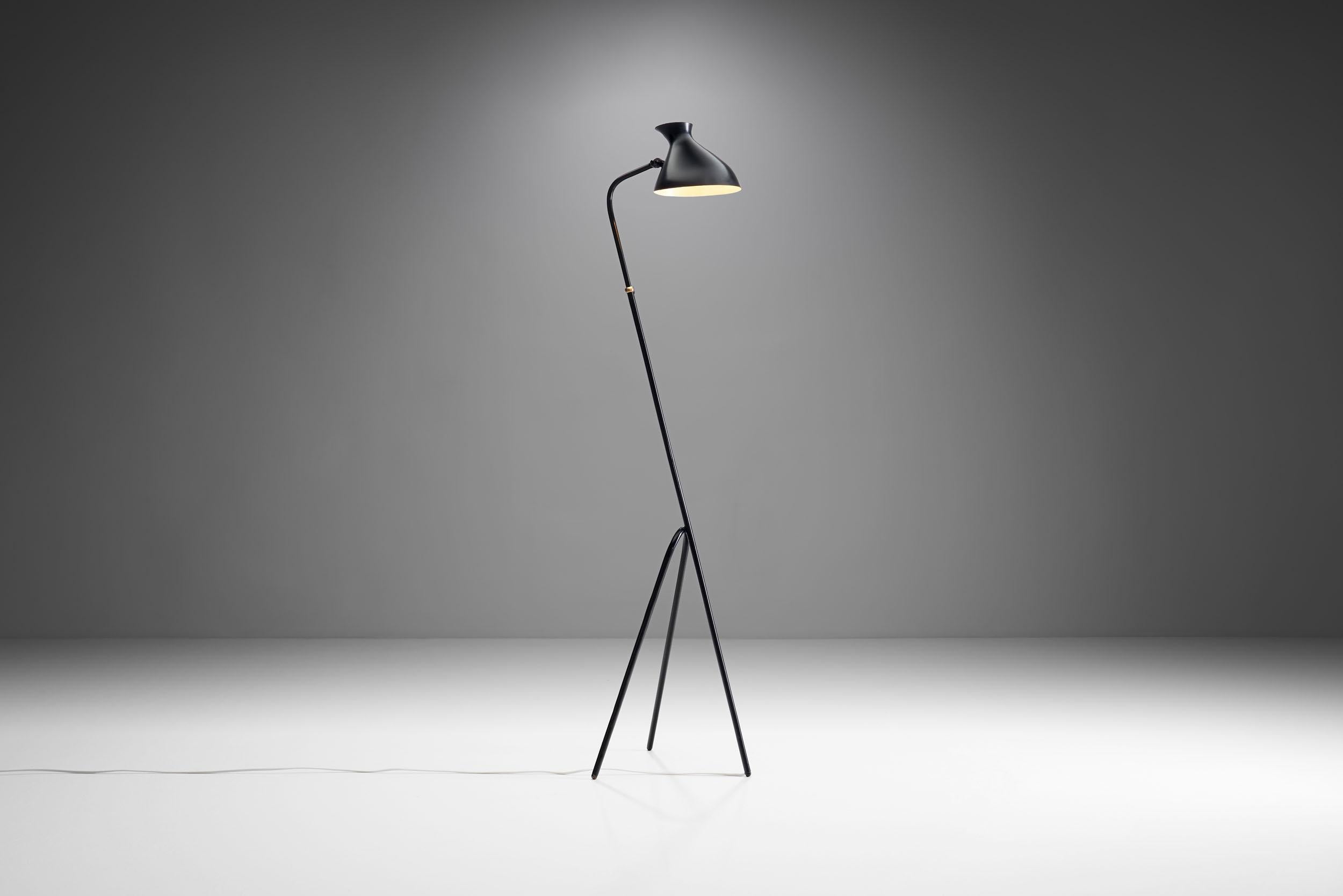 This characteristic floor lamp features a sleek appearance thanks to its distinctly shaped legs and shade. 

With its slender and elongated shape and black lacquered body, this lamp is a great modernist piece that stands out in any space. The