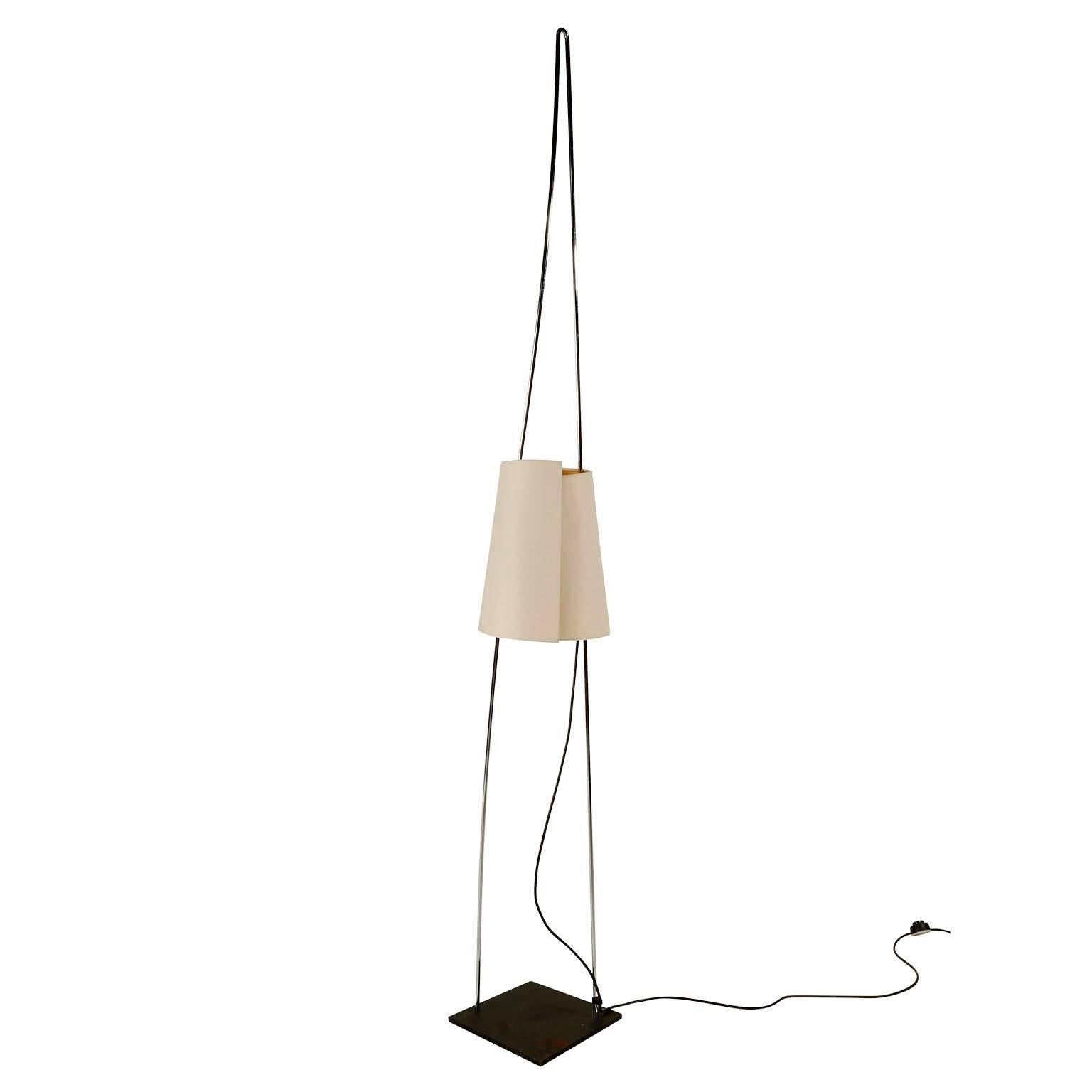 An Italian sculptural floor lamp by Italiana Luce manufactured in midcentury, circa 1970.
The stand is made of a curved chromed metal loop which is mounted on a black iron base. The lampshade is covered with a fine structured fabric in a beige tone