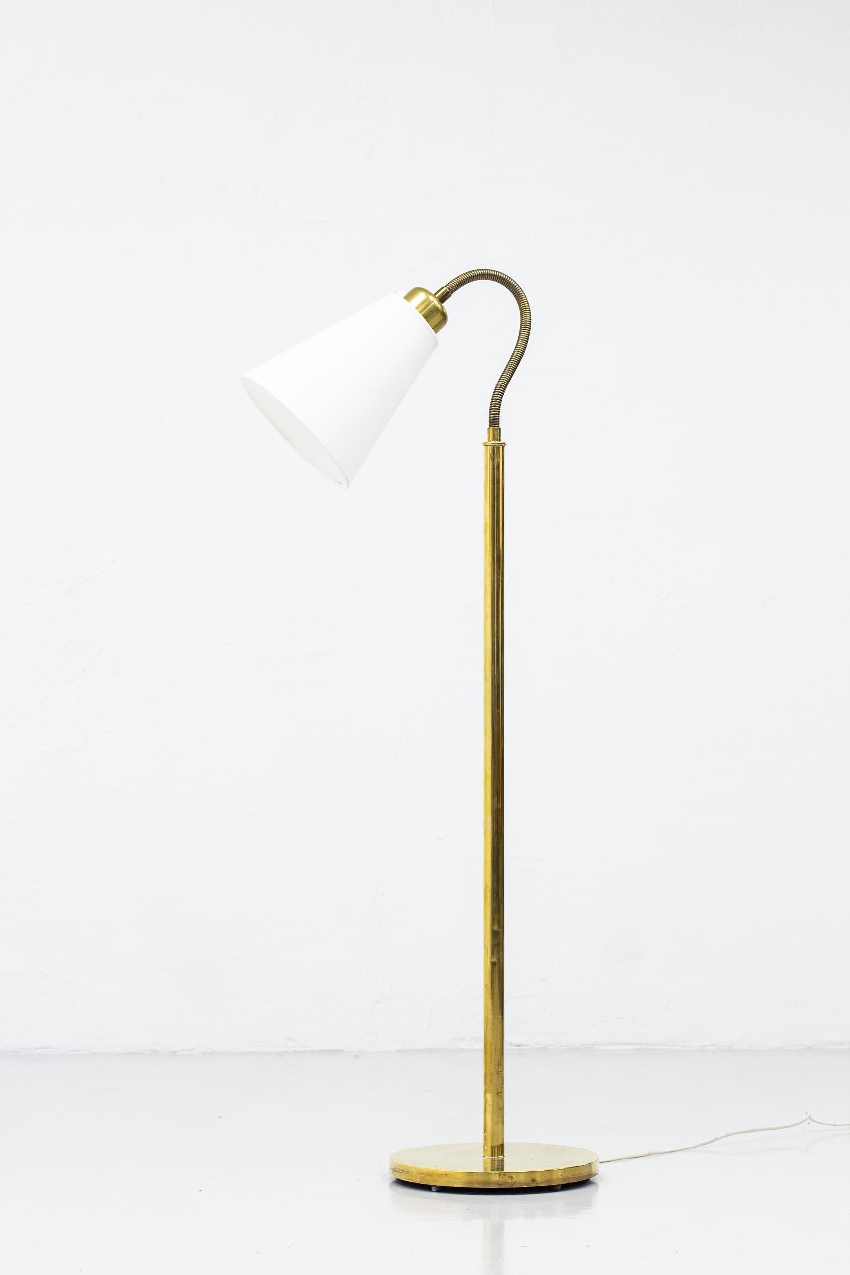 Floor lamp designed by Josef Frank and produced by Svenskt Tenn in Sweden during the 1940s (designed in 1934). Early version of the 1838 floor lamp. Made from brass with later white lamp shade in cotton. Good vintage condition with few signs of wear