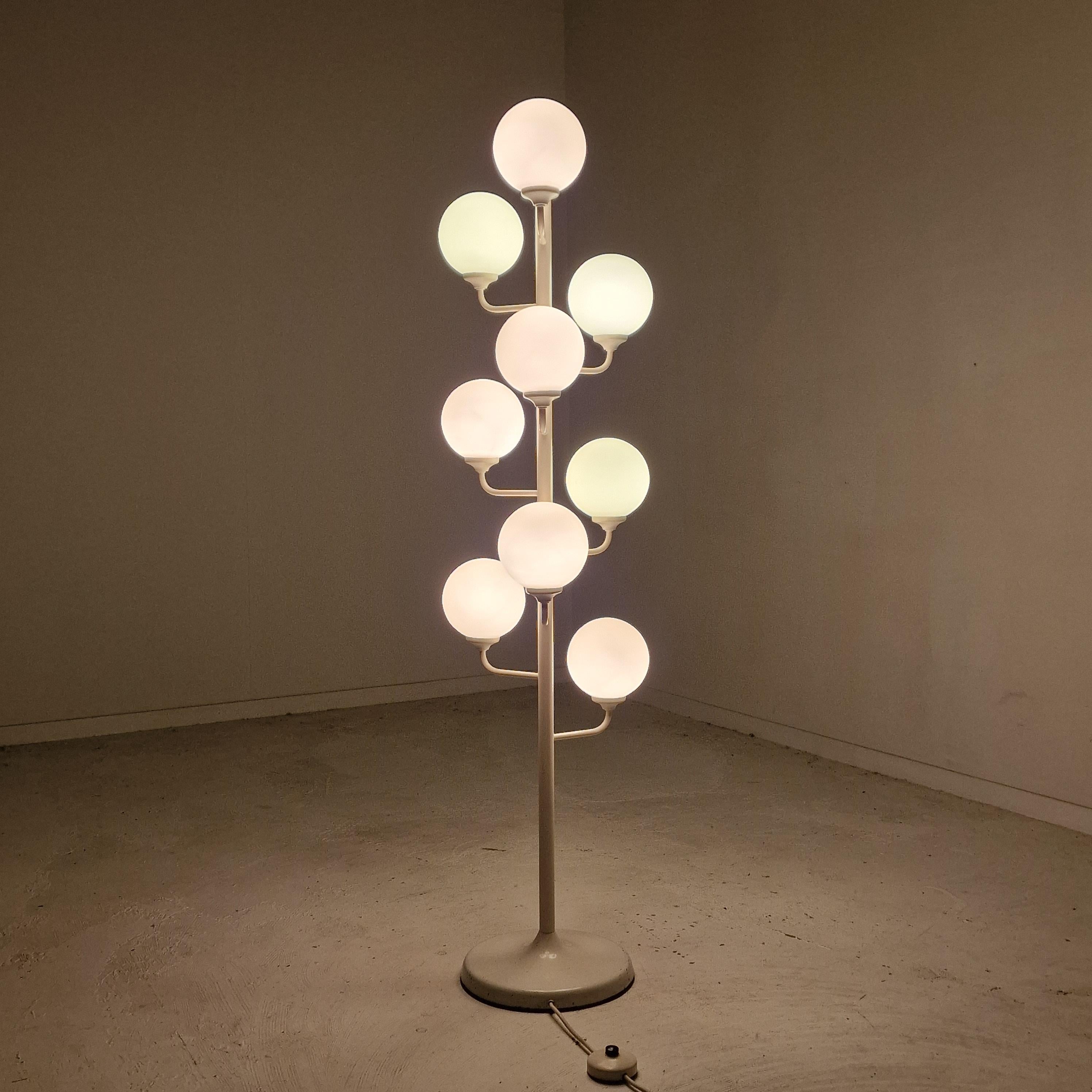 A beautiful Midcentury floor lamp made by Kaiser Leuchten in Germany in the 1980's. 

It is fascinating with its Space Age design and nine arms with milk glass balls. 

The bottom, the bar and the arms are made of metal. 

The glass bulbs show no