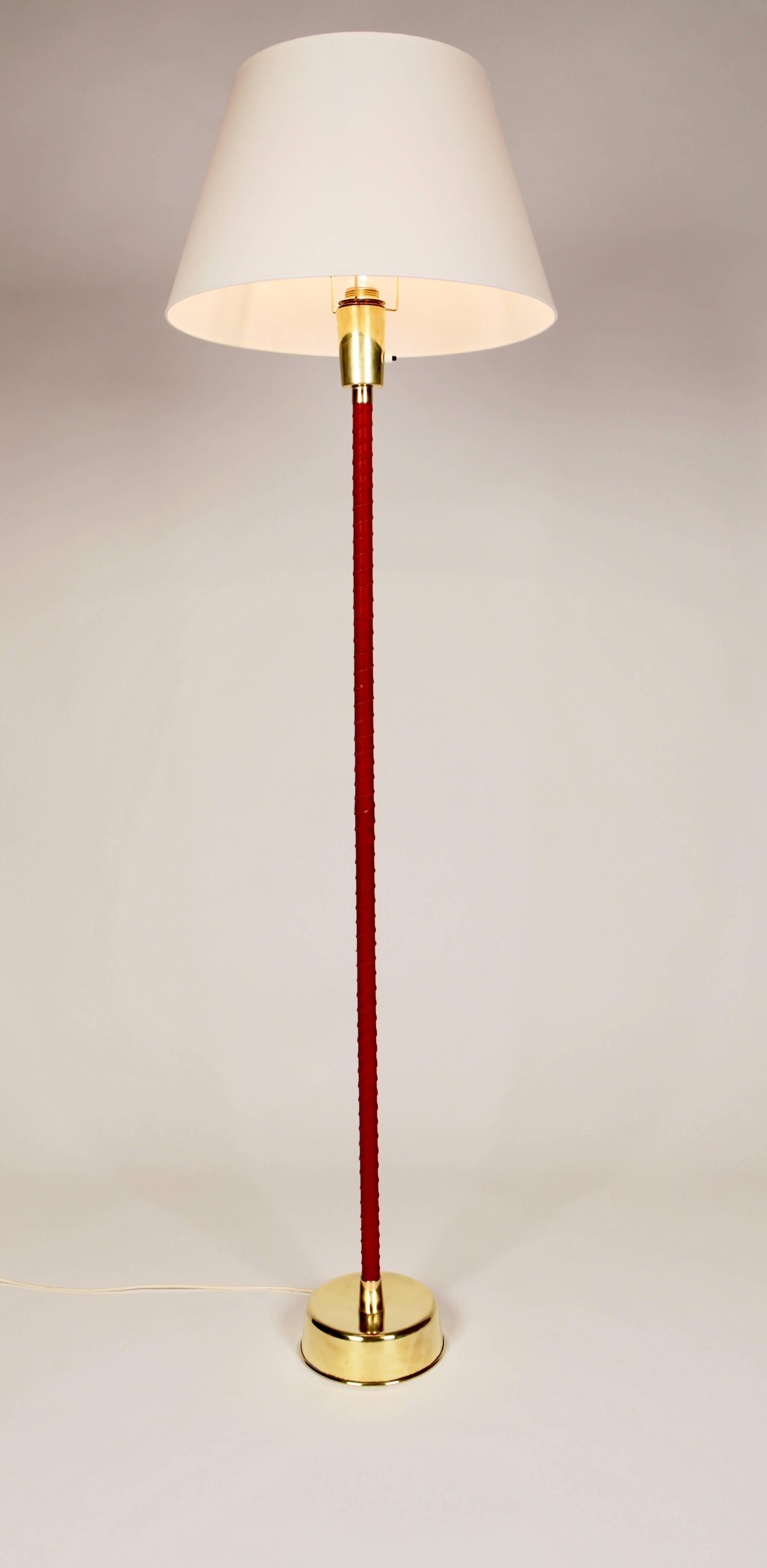 Lisa Johansson-Pape.
Floor lamp, manufactured by Orno in Finland.
Red leather covered pole and brass socket.
Excellent condition, replaced shade.
Designed in the 1940s.