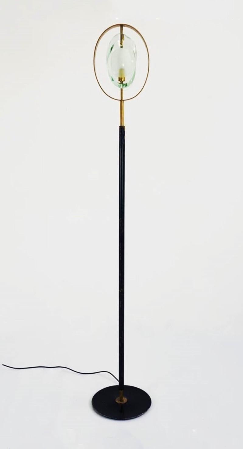 An elegant floor lamp designed by Max Ingrand for Fontana Arte, Model 2020, Italy, 1961. Organically shaped double lens cutted with chisel panels of thick Murano polished glass with sandblasted centers fitted within a natural brass ring supported by