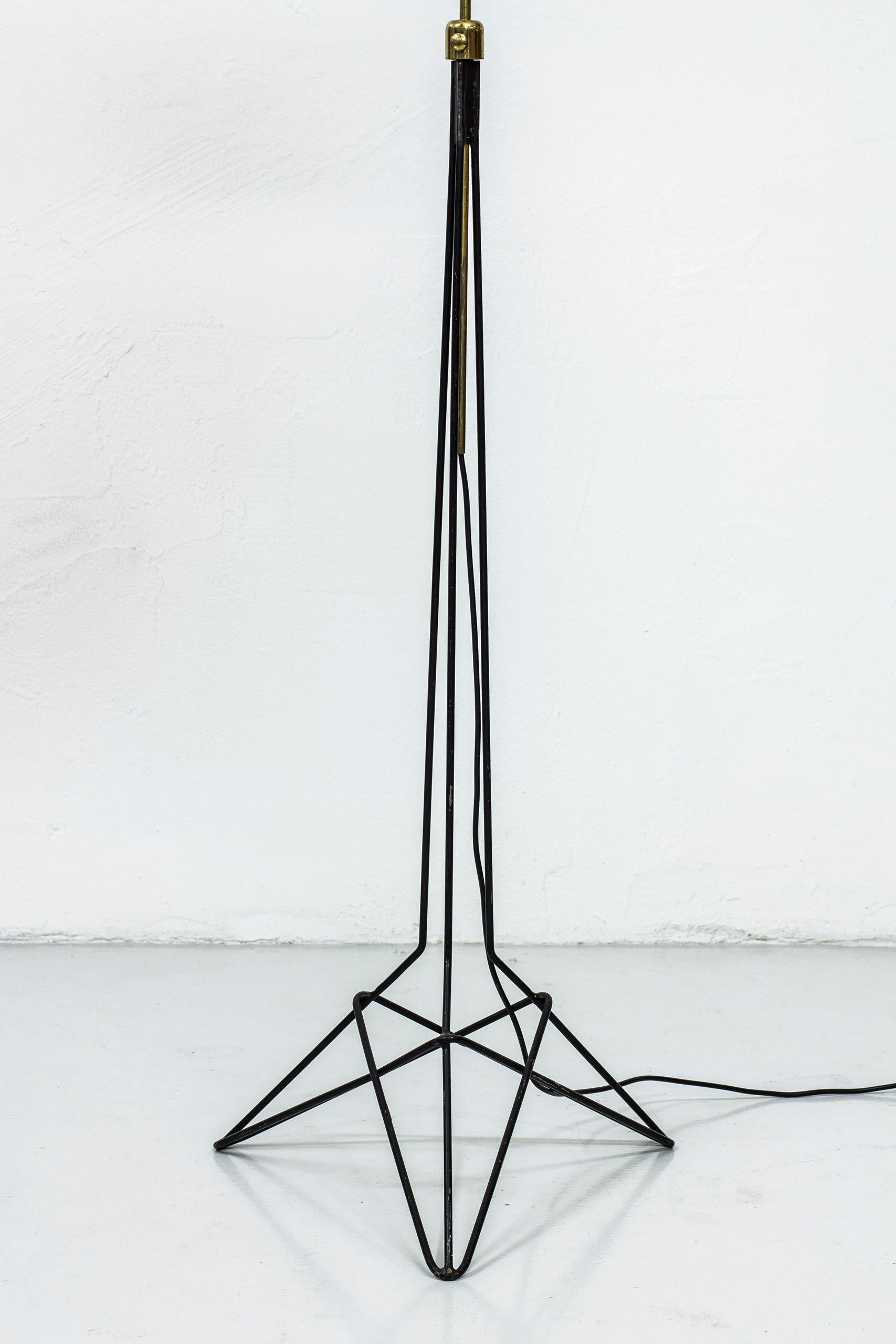 Floor lamp designed by Nils Strinning. Produced by his own company String Design during the 1950s. Black lacquered metal base and brass. New hand sewn, pleated, chintz fabric shade in off-white. Light switch on the lamp fixture. Good vintage