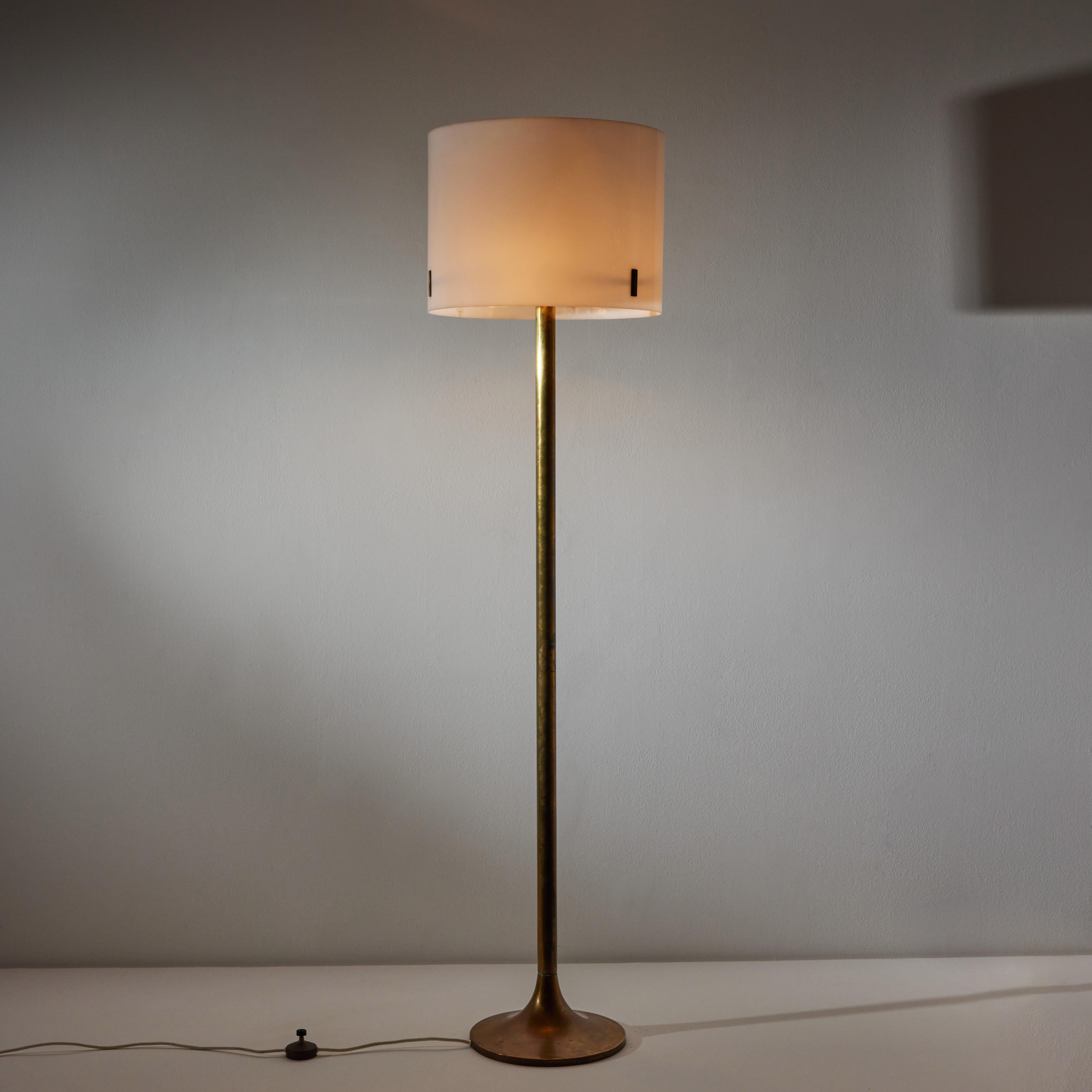 Floor lamp by Oluce. Manufactured in Italy, circa 1960's. Acrylic shade, brass stem and base. Original European cord with step switch. We recommend one E27 60w maximum bulbs for the uplight and three E27 60w bulbs for the downlight. Bulbs provided