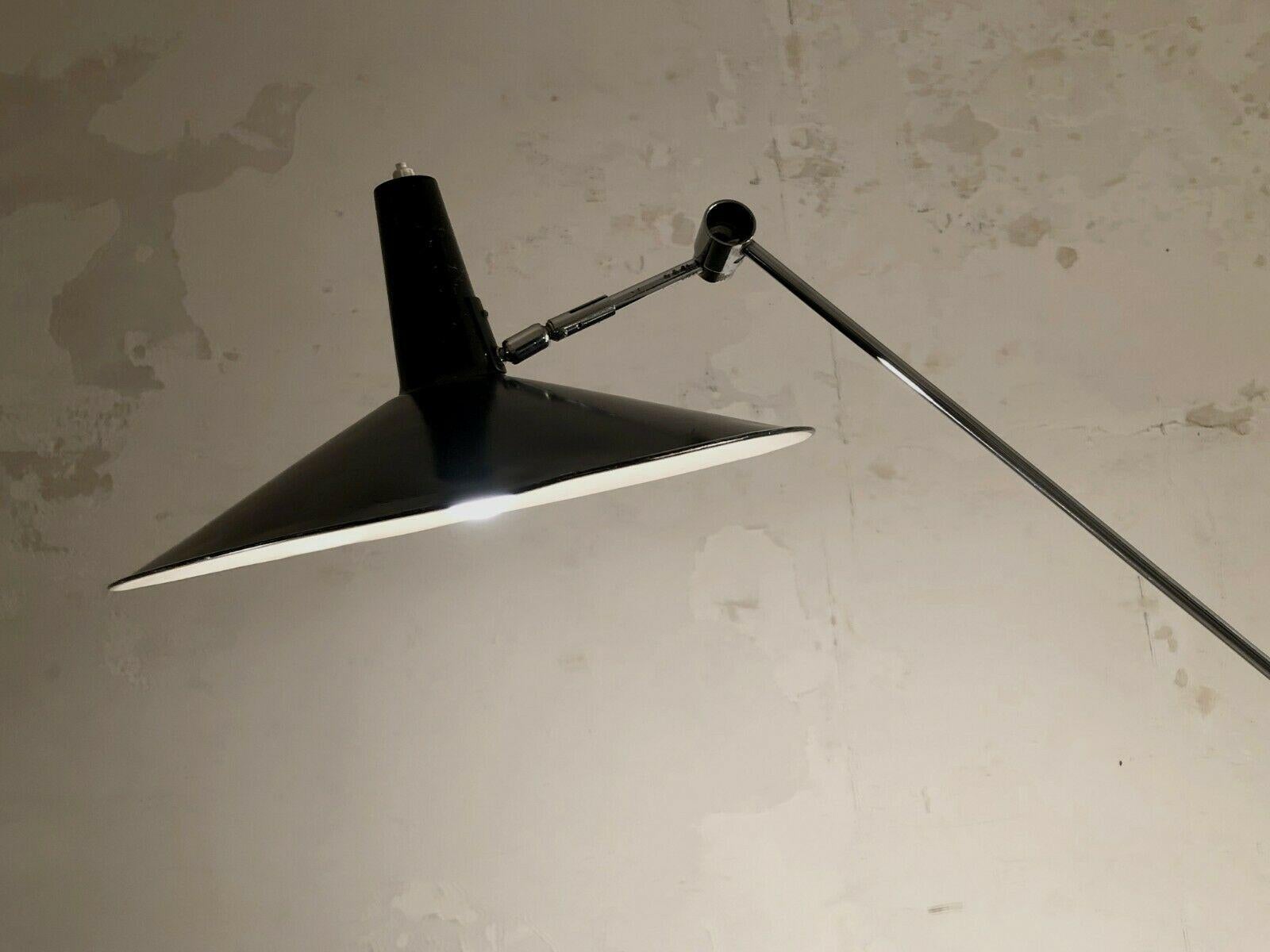 An outstanding counter-balanced floor lamp, Mid-Century Modern, with a circular base in cast iron, 2 articulated arms, an abat-jour in black lacquered aluminium by 
Rico & Rosemarie Baltensweiler, Switzerland 1950-1960. 
The dimensions of this