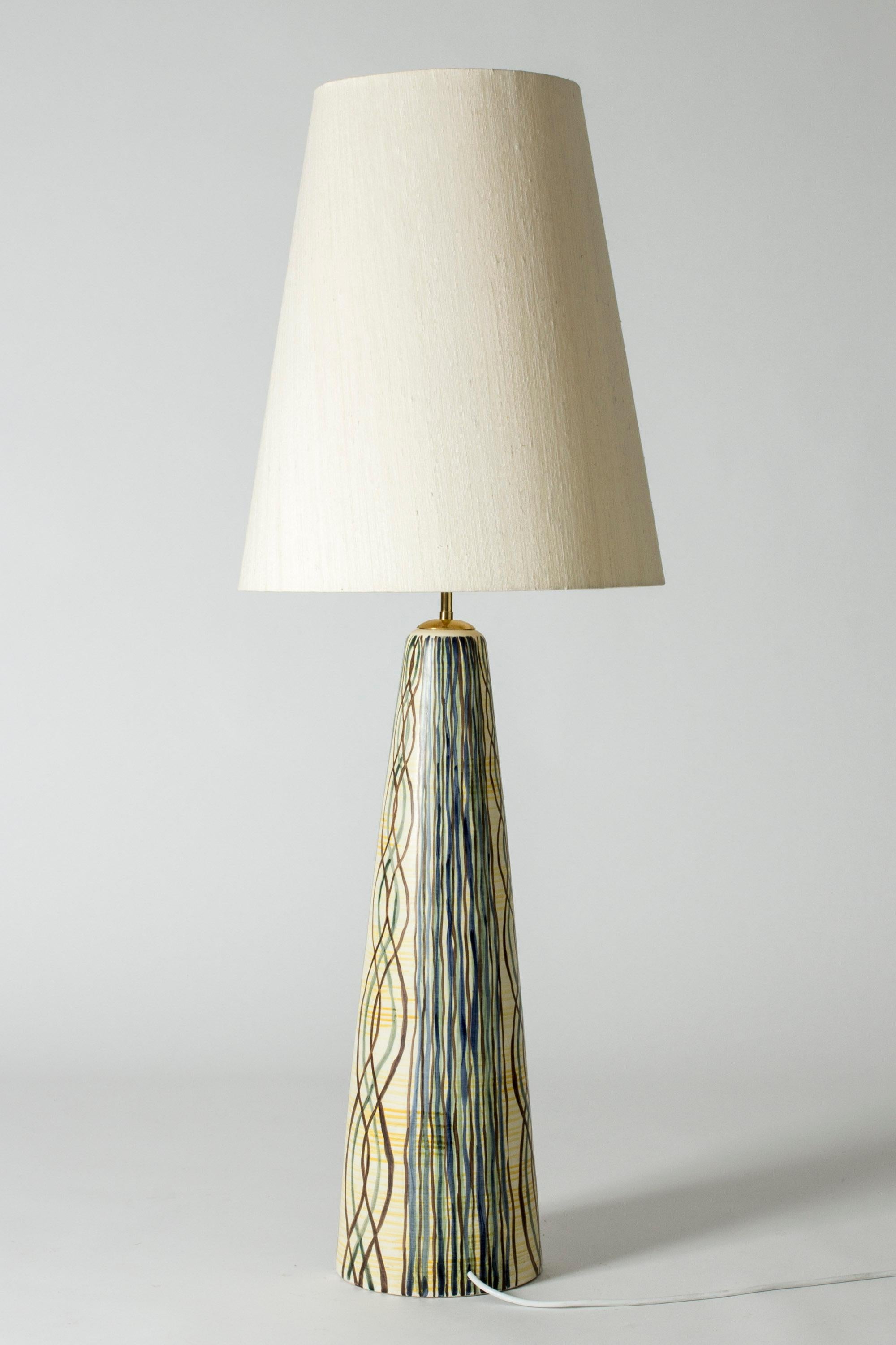 Floor lamp by Rigmor Nielsen, with a heavy, conical ceramic base and oversized original lamp shade. The base is decorated with a beautiful organic pattern of billowing lines in subdued colors.