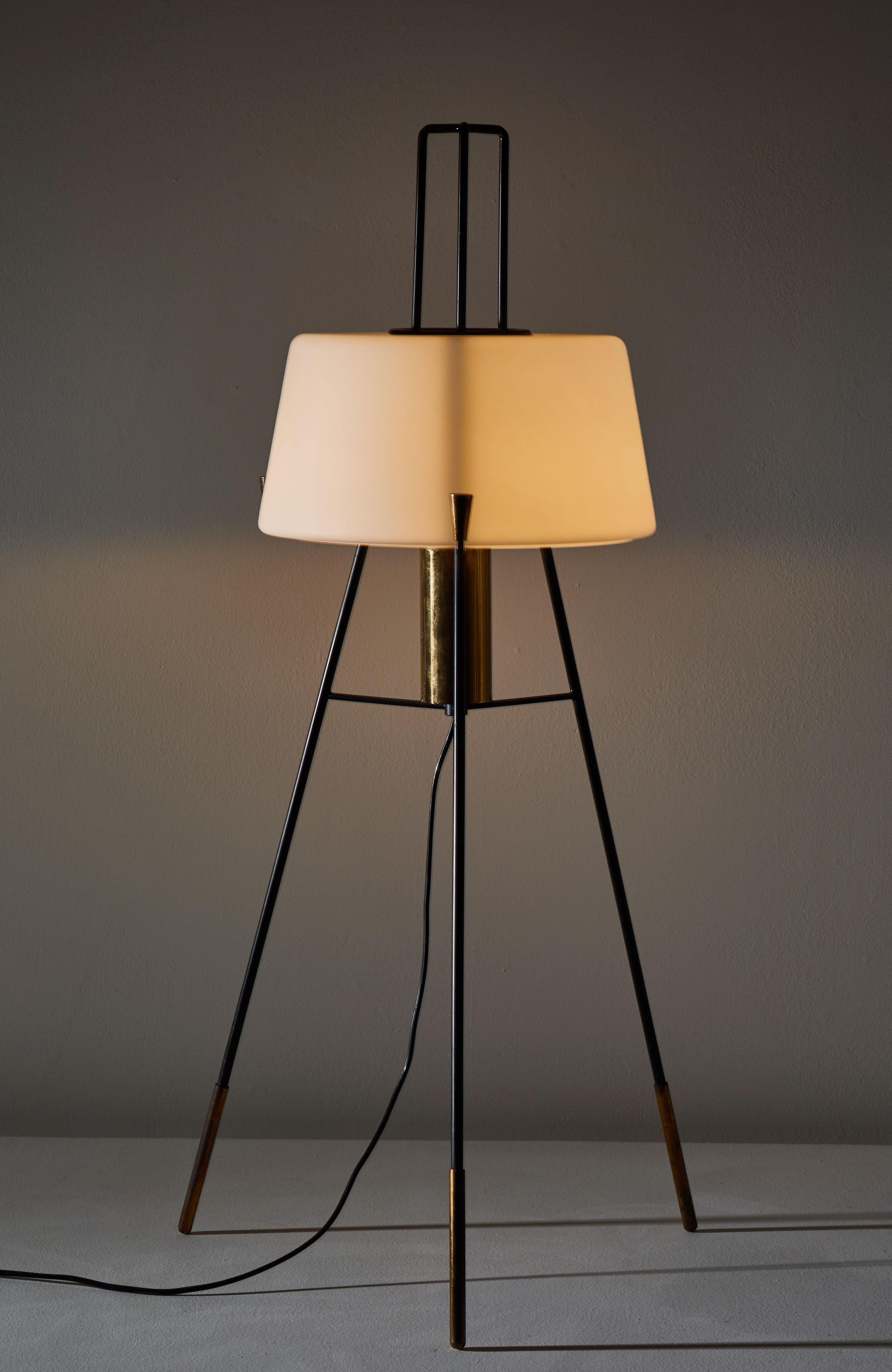 Floor lamp by Stilnovo. Manufactured in Italy, circa 1950s. Brushed satin glass diffuser, enameled metal tripod base, brass hardware. Original cord with brass step switch. Not wired for US, comes with adapter. Takes one E27 100w maximum bulb.