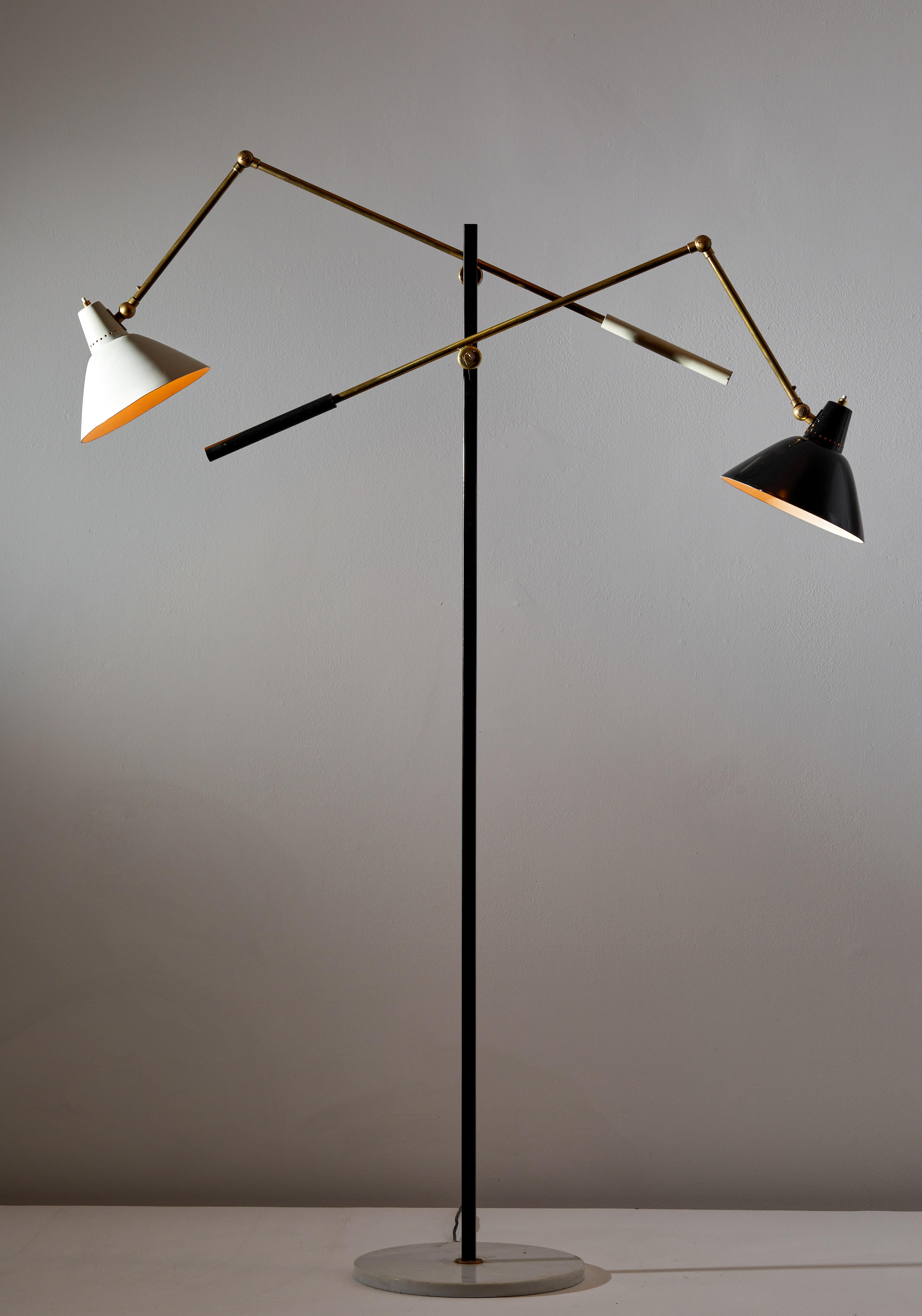Two-arm floor lamp by Stilnovo. Manufactured in Italy, circa 1950s. Marble, brass, enameled metal. Arms and shades adjust to various positions. Rewired for U.S. sockets. Retains original manufacturer's label. Takes two E27 100w maximum bulbs. Bulbs