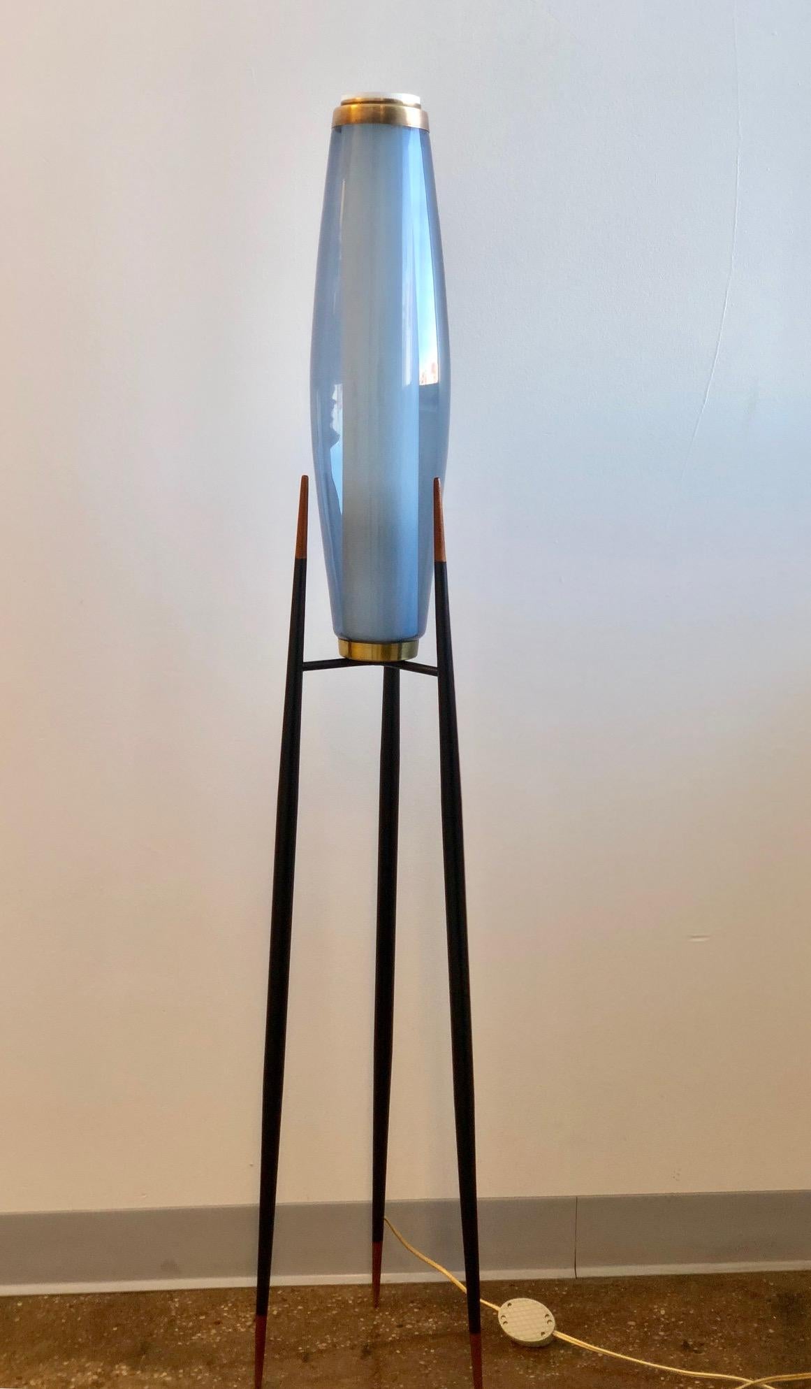 A rare floor lamp designed by Svend Aage Holm Sørensen. Black-lacquered metal and brass on three feet terminating with pointed pieces of teak, internal shade in opal hand blown glass and outer shade in blue hand blown glass, produced by Holmegaard.