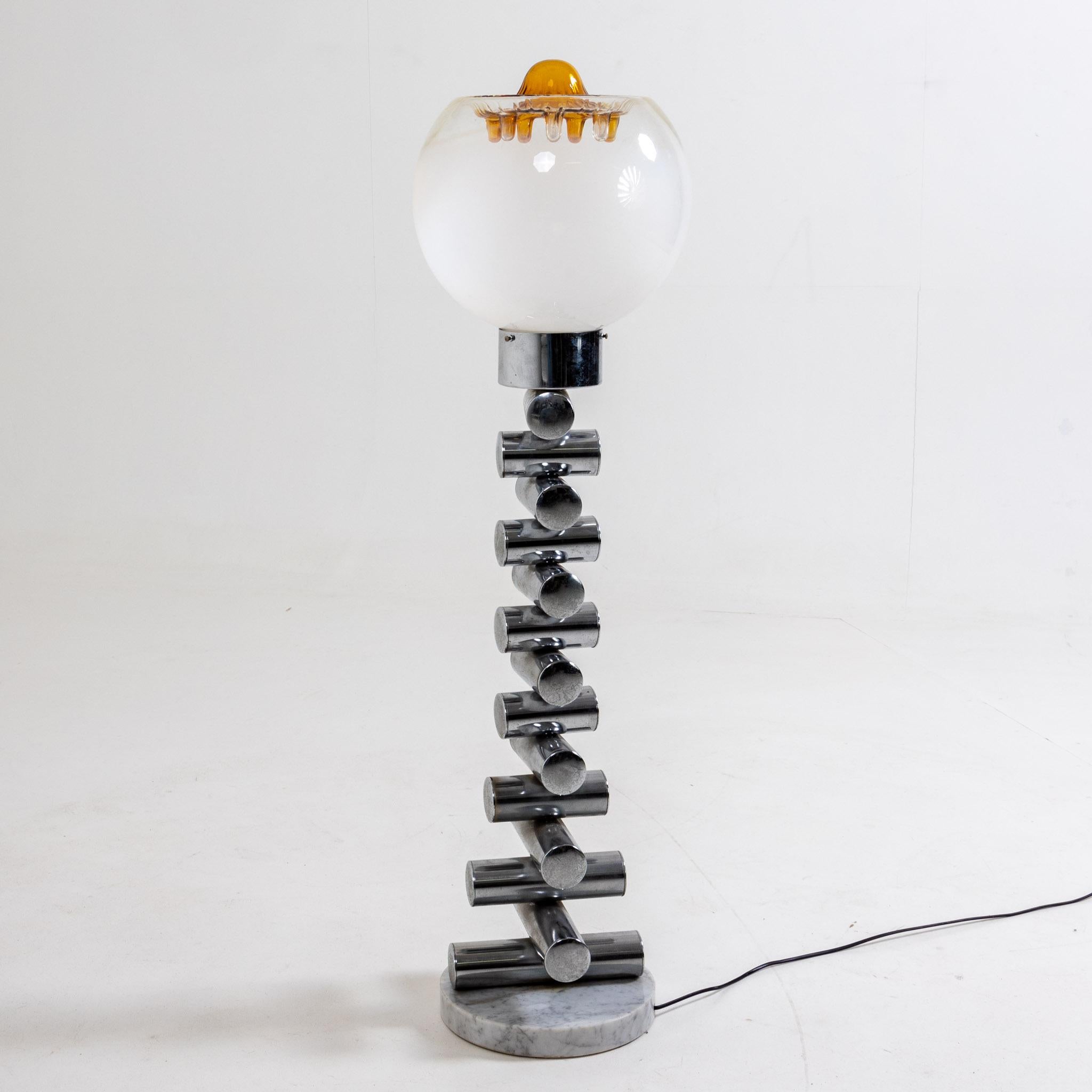 Floor lamp standing on round marble disc with chrome stem made of cylindrical elements and spherical glass shade with amber drop decoration.
