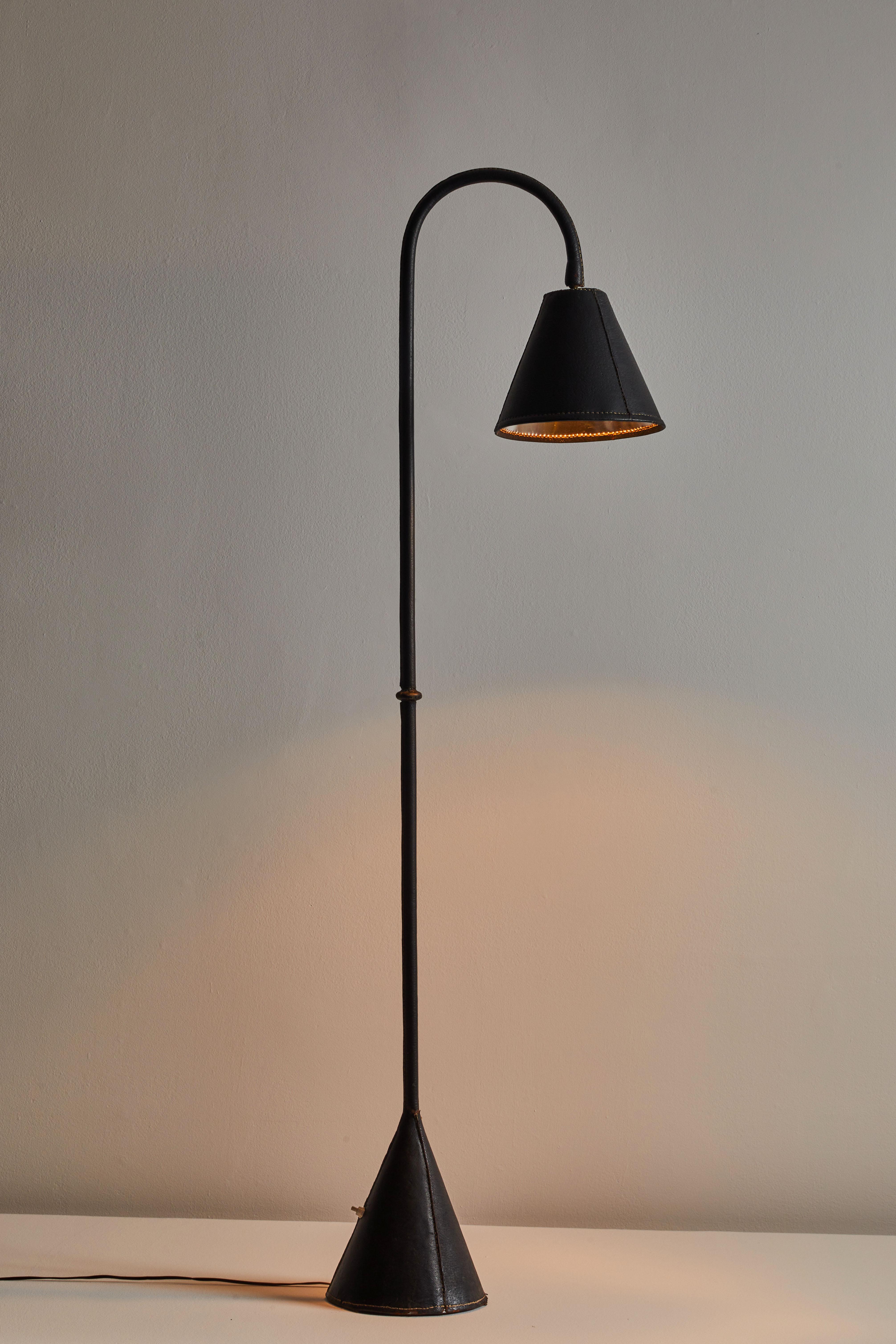 Floor lamp by Valenti. Manufactured in Spain, circa 1960s. Saddle-stitched distressed leather over steel. Shade articulates up/down and left/right. On/off switch on base of lamp. Rewired for U.S. sockets with black French twist cord. We recommend
