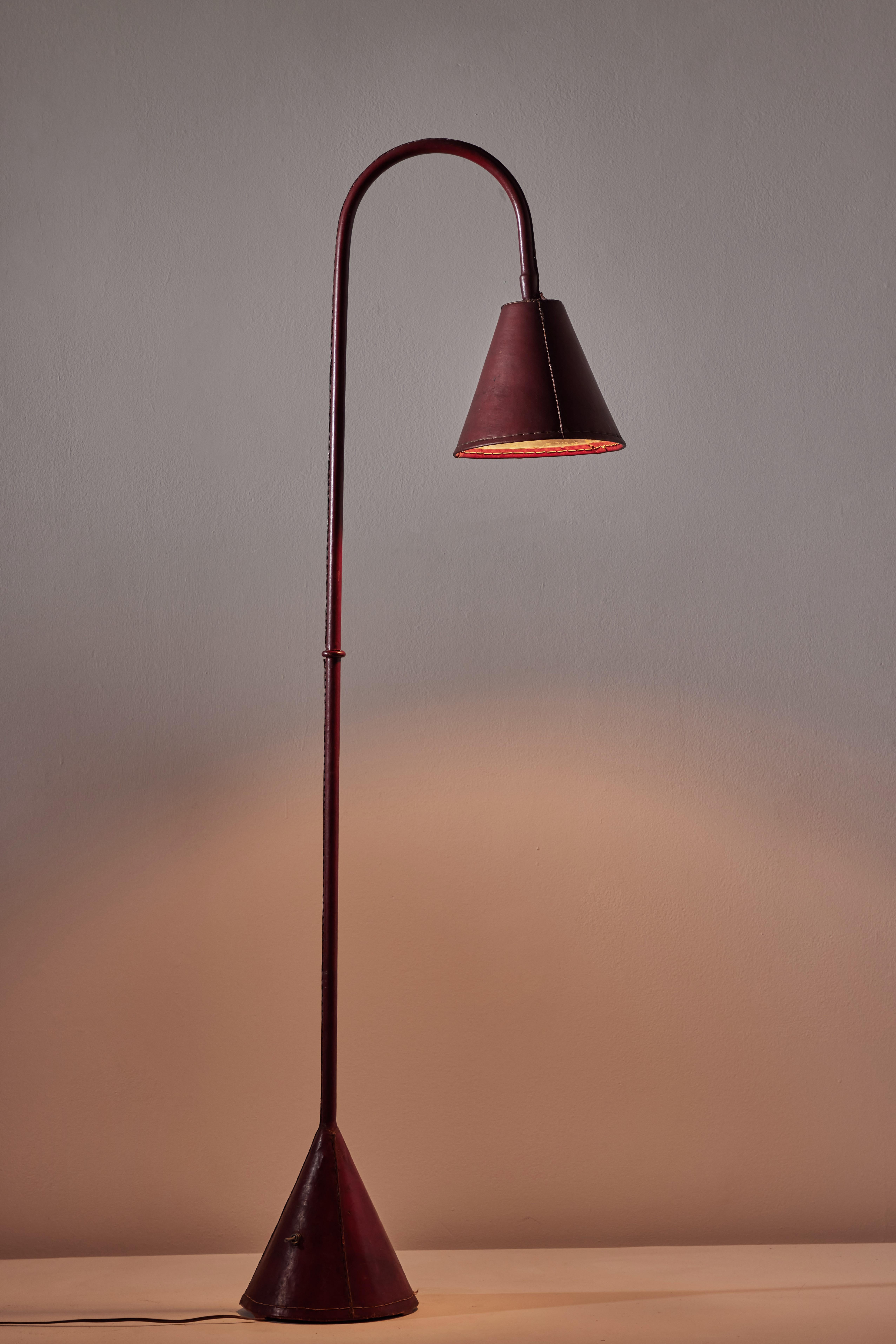 Floor lamp by Valenti. Manufactured in Spain, circa 1950s. Saddle-stitched distressed leather over steel. Shade articulates up/down and left/right. On/off switch on base of lamp. Original European cord, U.S. adaptor provided. We recommend one E27