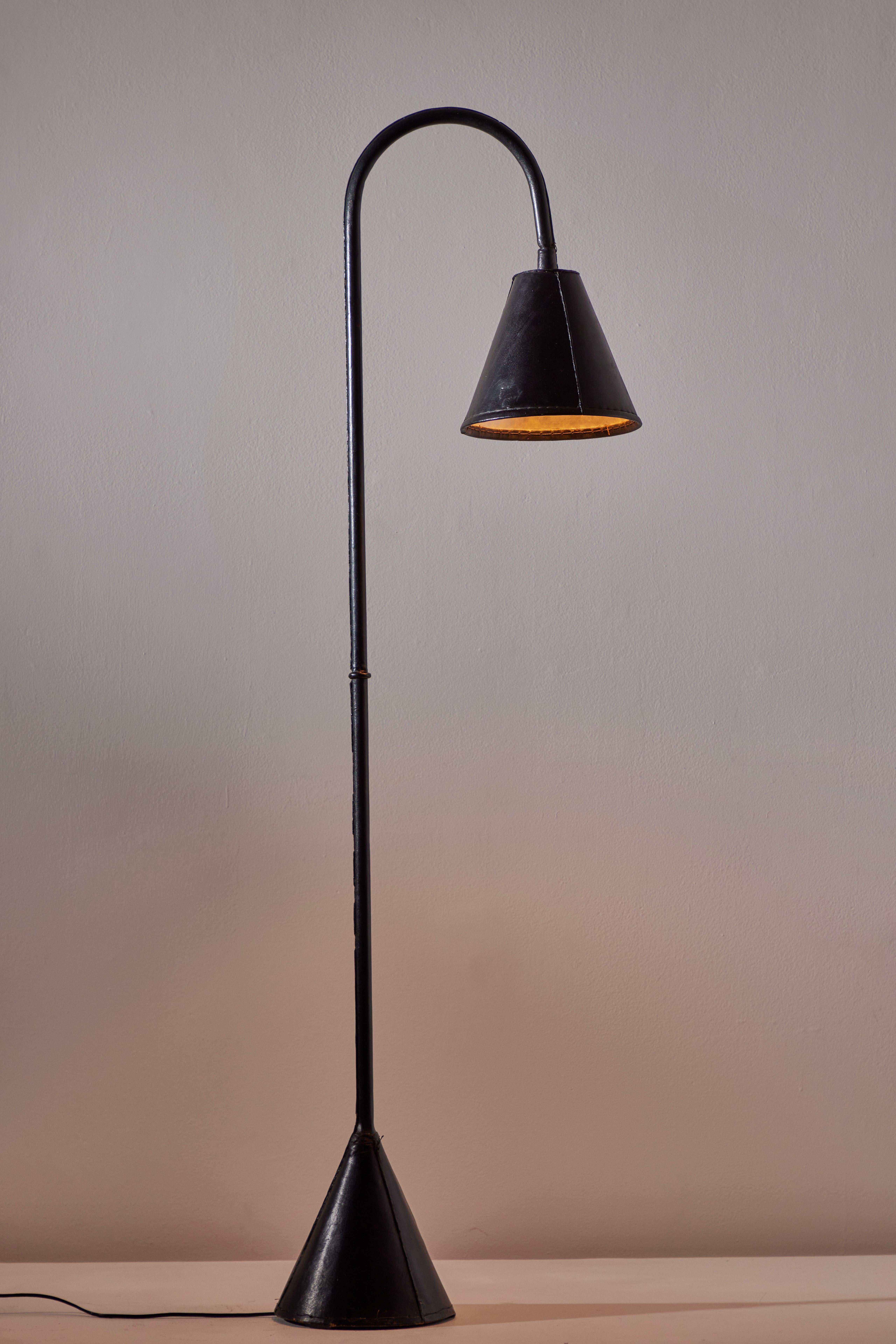 Floor lamp by Valenti. Manufactured in Spain, circa 1950s. Saddle-stitched distressed leather over steel. Shade articulates up/down and left/right. On/off switch on base of lamp. Original European cord, U.S. adaptor provided. We recommend one E27