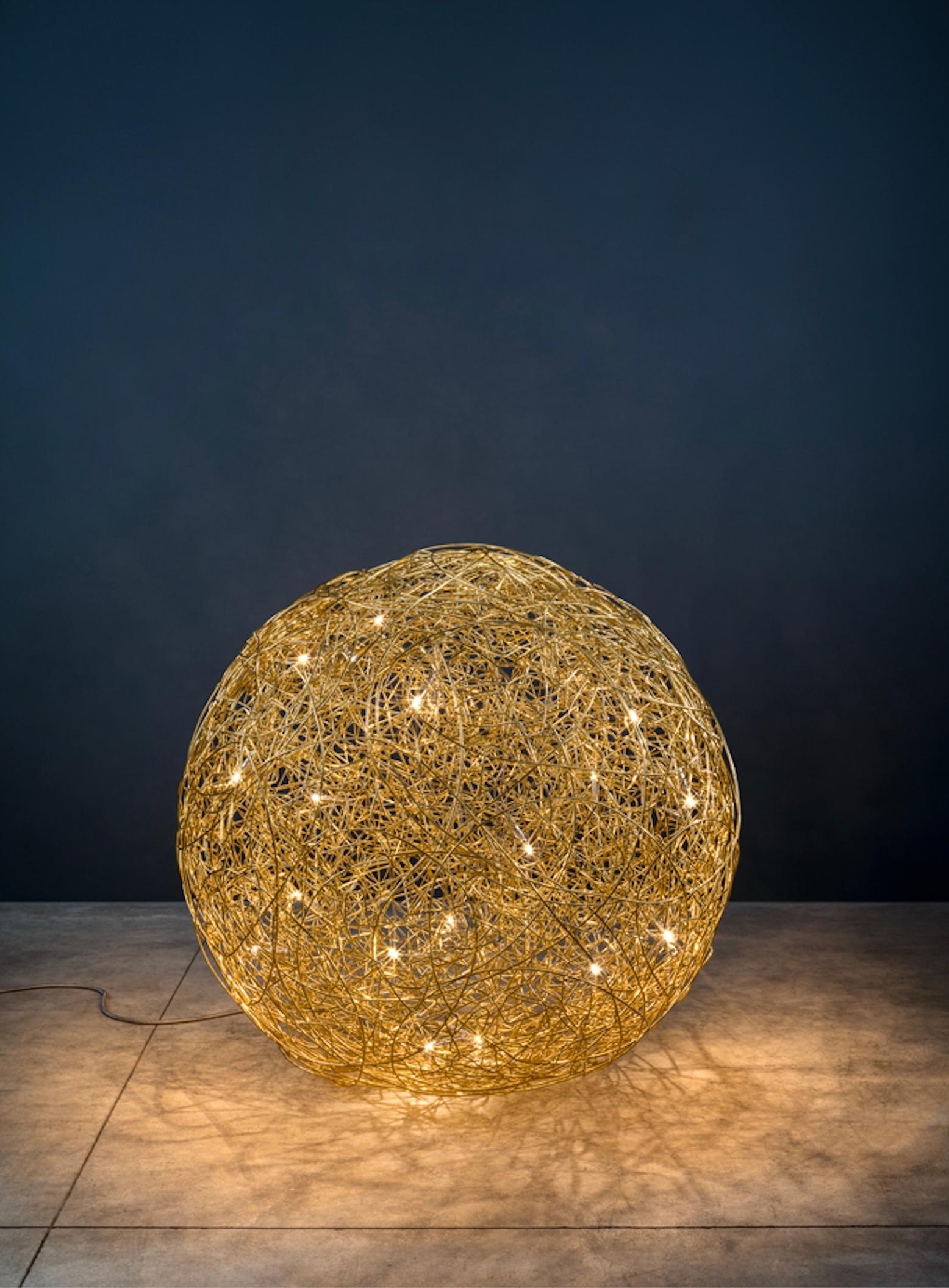 La Fil de Fer, diseñada por Enzo Catellani, es una lámpara de pie de autor fabricada con alambre de aluminio trenzado e iluminada desde dentro. Creada inicialmente hace casi veinte años para un encargo especial, fue redescubierta en el taller del