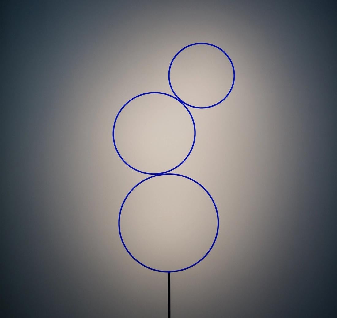 La Sorry Giotto, diseñada por Enzo Catellani, es una lámpara de pie escultural inspirada en la pureza del círculo. Catellani buscaba crear un diseño mínimamente intrusivo que enfatizara las formas limpias, y en el momento en que lo encendió, le vino