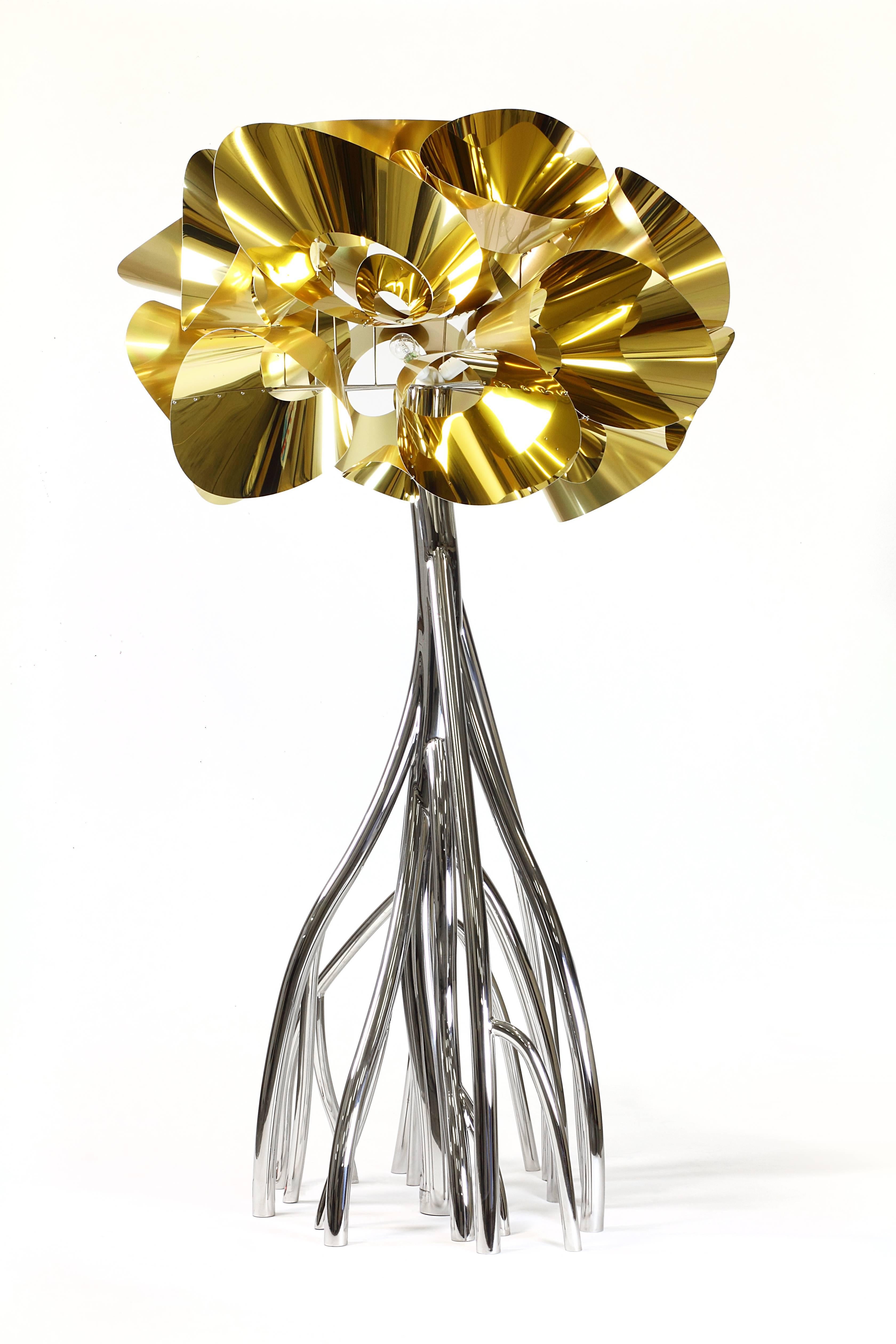 La lampe Mangrovia est composée de 18 tubes en acier inoxydable poli miroir. Chaque tube est plié, coupé, soudé et hautement poli à la main. L'abat-jour est composé de fleurs en aluminium doré. Source d'éclairage : Trois ampoules à filament