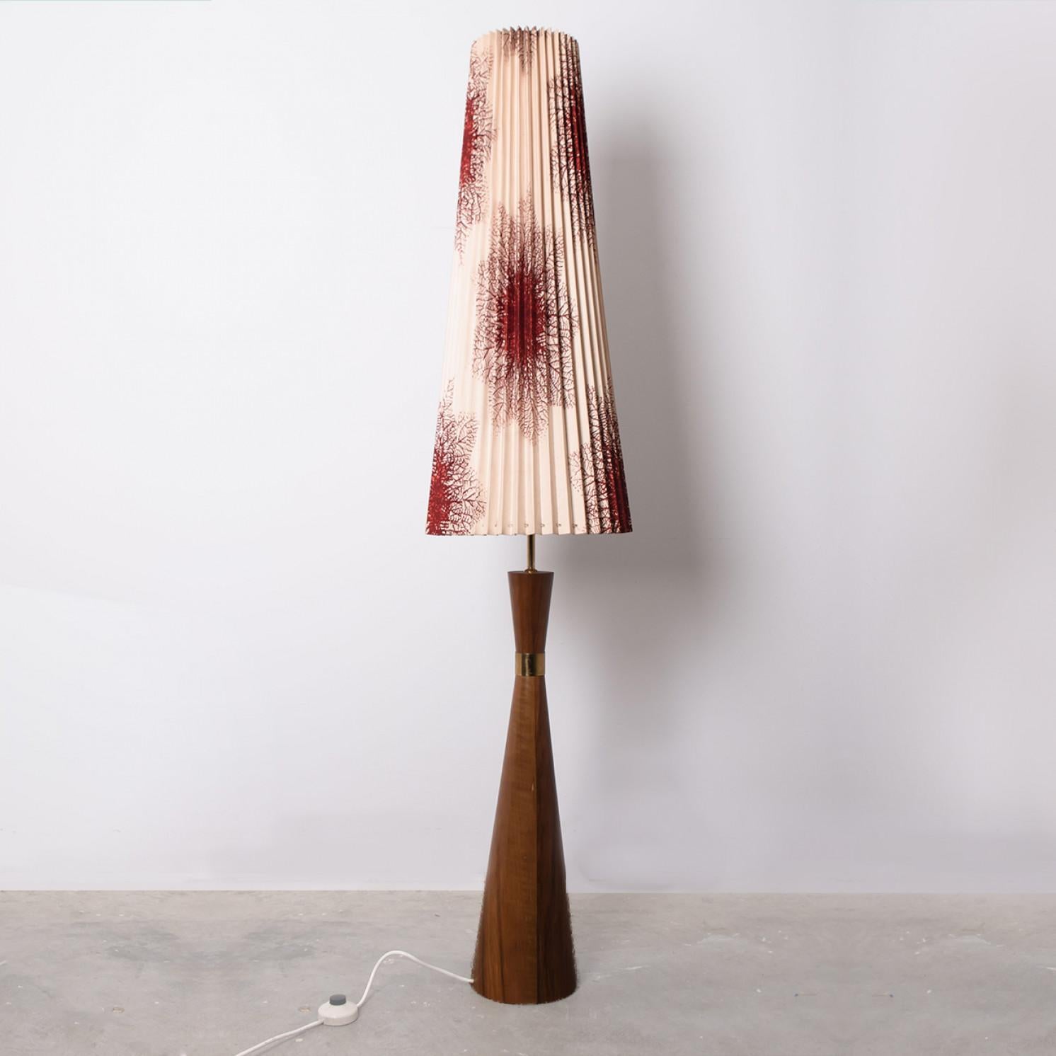 Beautiful floor lamp by Knoll, manufactured circa 1970. Red and beige shade with beautiful patterns, illuminates beautifully. The base is made of wood with a classy ring in the middle, giving it a formal and exciting look. A real statement