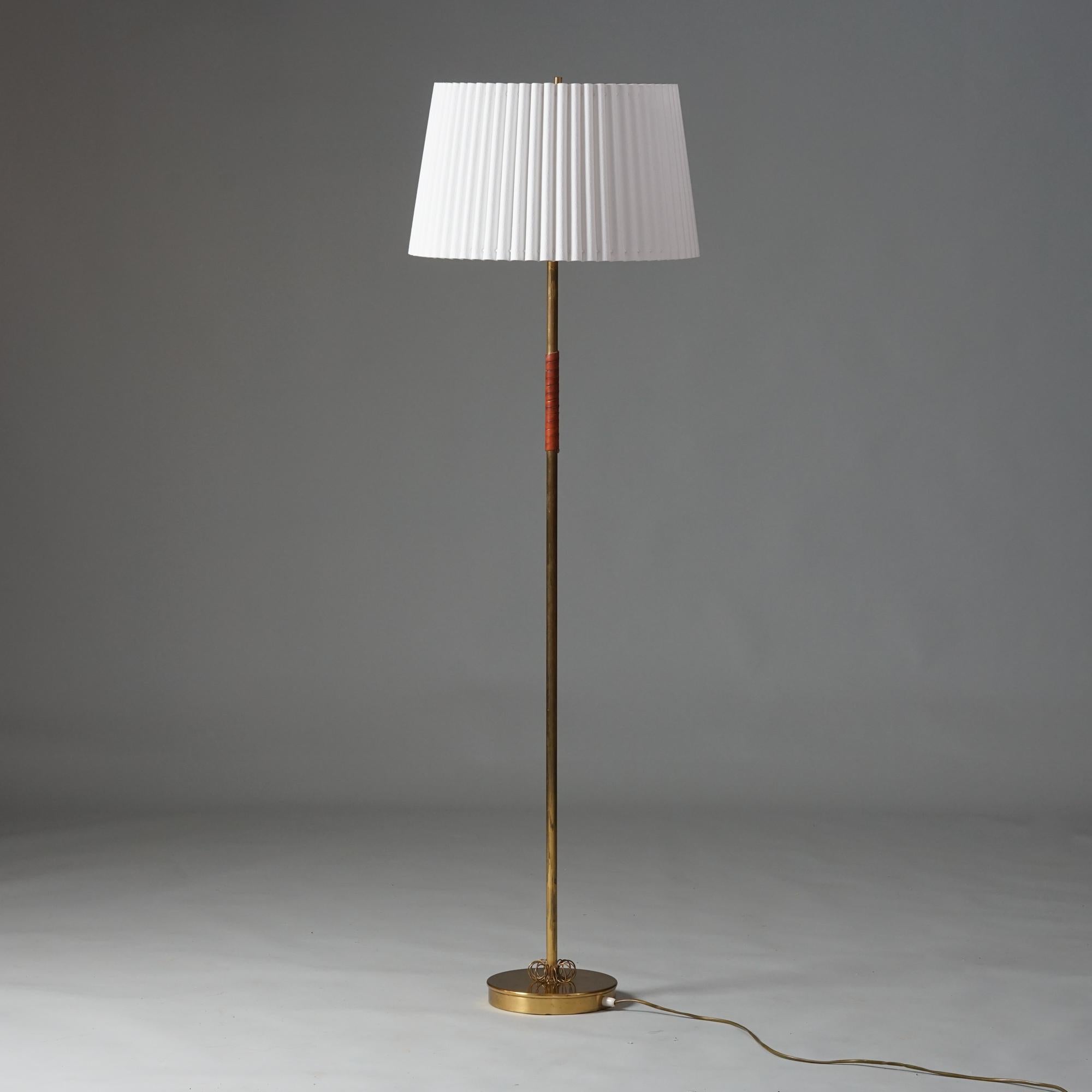 Lámpara de pie, fabricada en Finlandia, años 50. Marco de latón, cuero y detalles de latón. Pantalla de tela renovada. Buen estado vintage, pátina menor acorde con la edad y el uso. Diseño moderno escandinavo atemporal. 