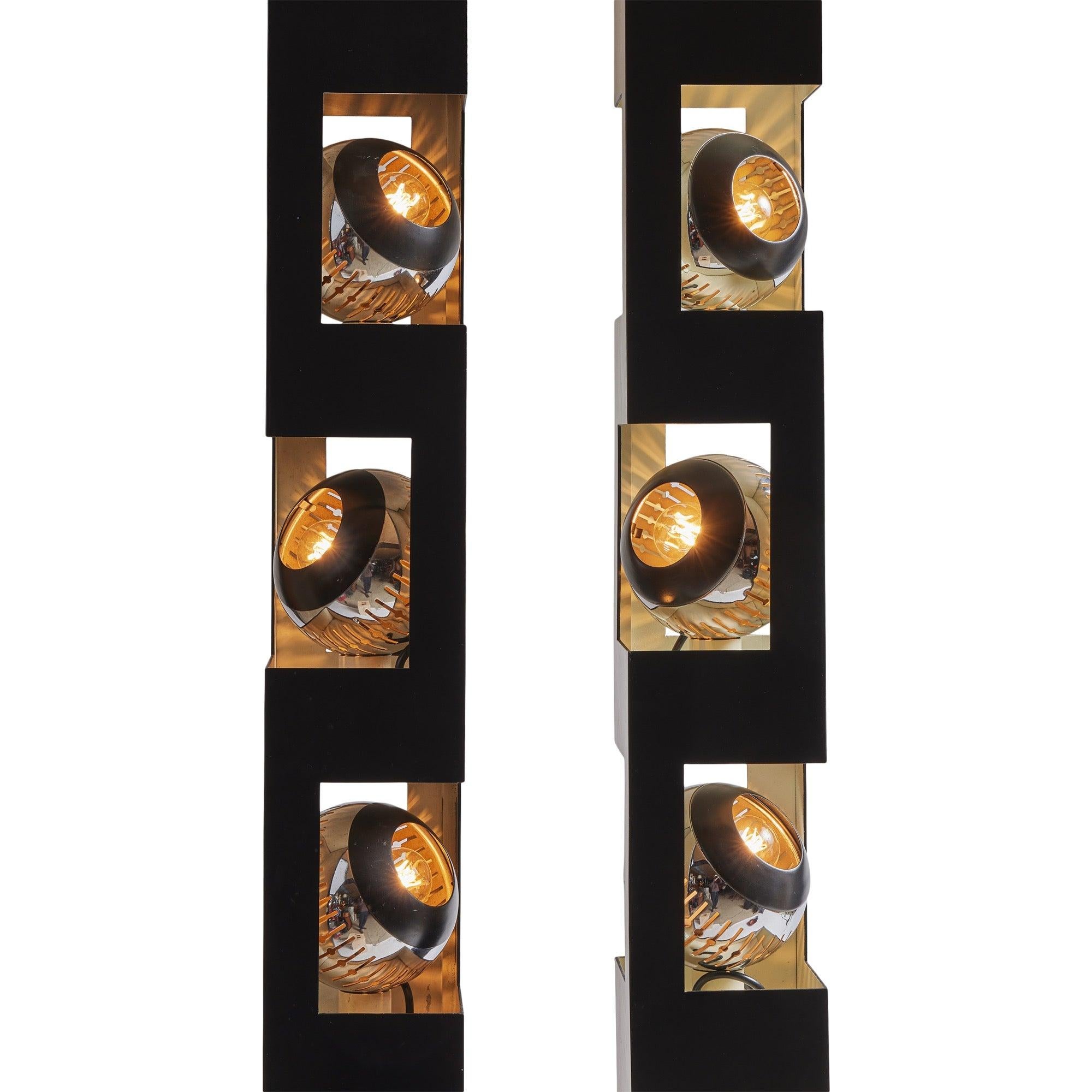 Eine Stehlampe aus geschwärztem Metall auf einem verchromten Sockel mit drei verstellbaren Chromschirmen und einem Oberlicht. Es sind zwei Vorrichtungen verfügbar.