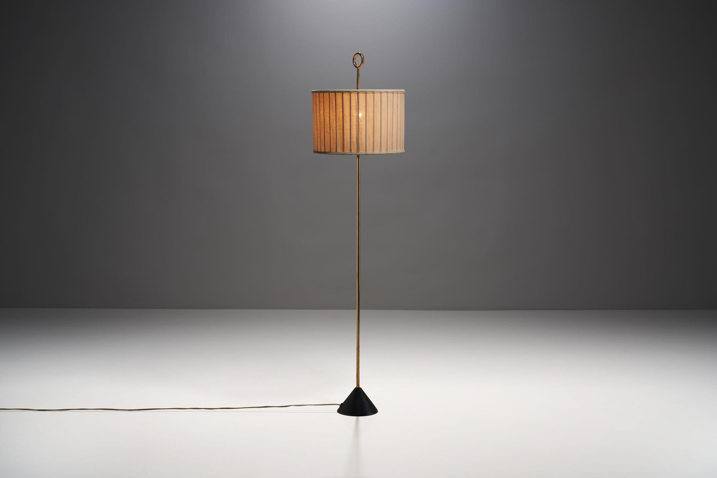 This floor lamp is the “G20” model by Swedish designer Hans-Agne Jakobsson. This mid-century model couples brass and fabric, creating a beautiful modern look.

This appealing and very rare lamp consists of a pleated fabric shade that is supported by
