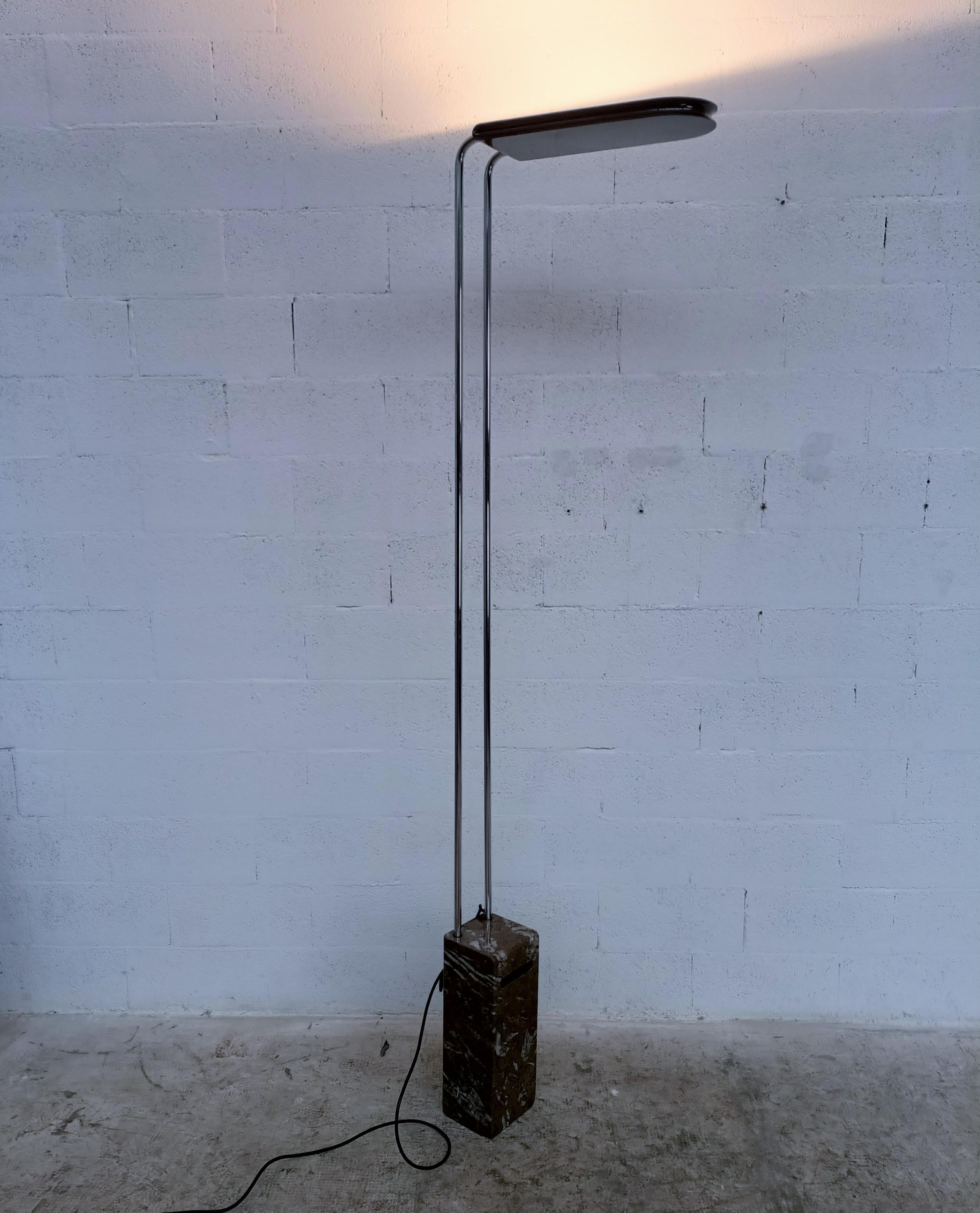 Gesto halogen floor lamp with marble base designed by Bruno Gecchelin and produced by Skipper 1970s.
It features a white marble base, black hood and chromed tubular body. Included is a dimmer that regulates the upward light beam, thus providing an