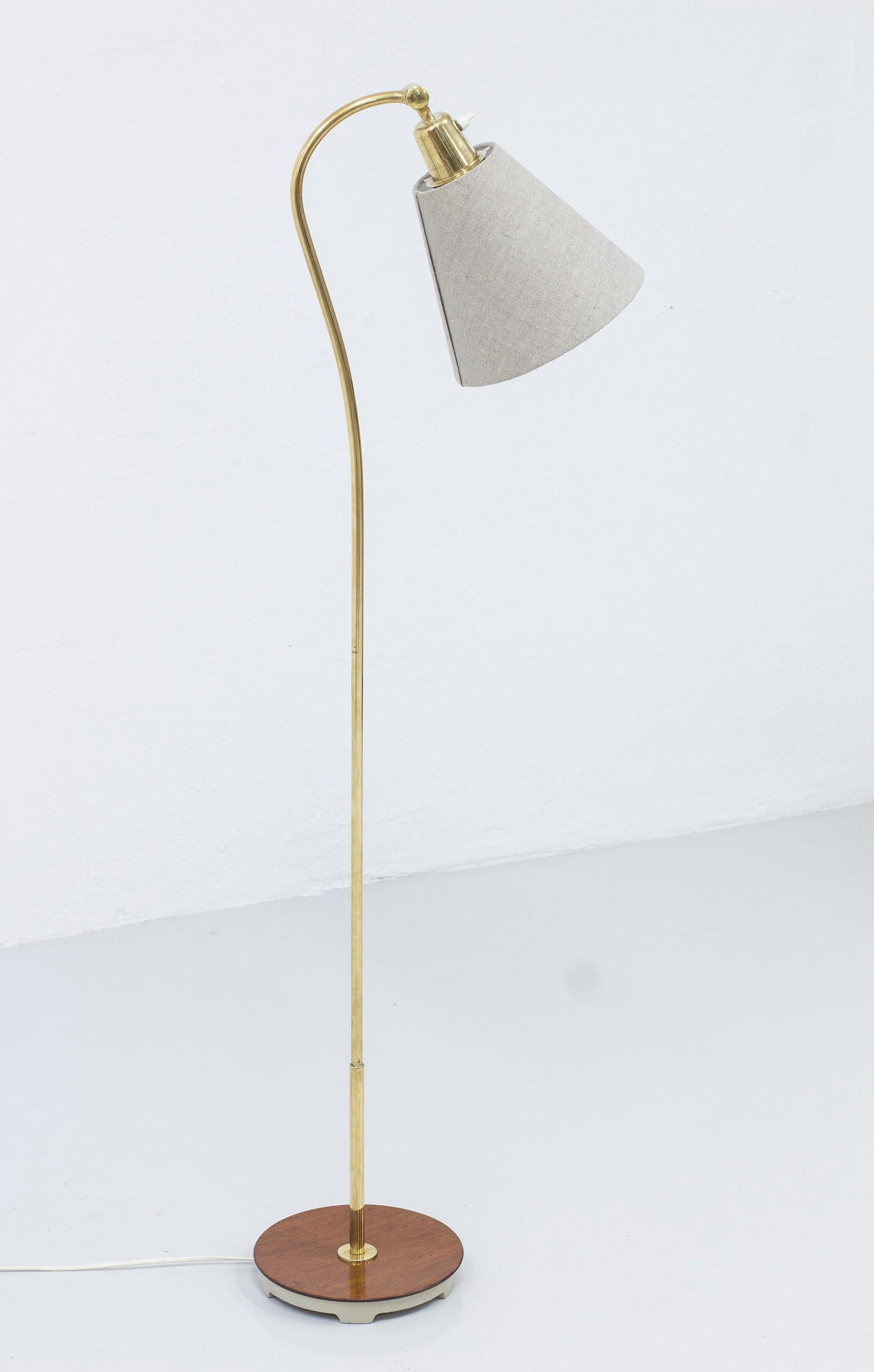 Floor lamp model 531011 designed by Bertil Brisborg. Produced by Nordiska Kompaniet for the Triva series. Designed around 1948 and produced sometime between there and the 1950s. Made from grey lacquered cast iron, mahogany and brass. New lamp shade