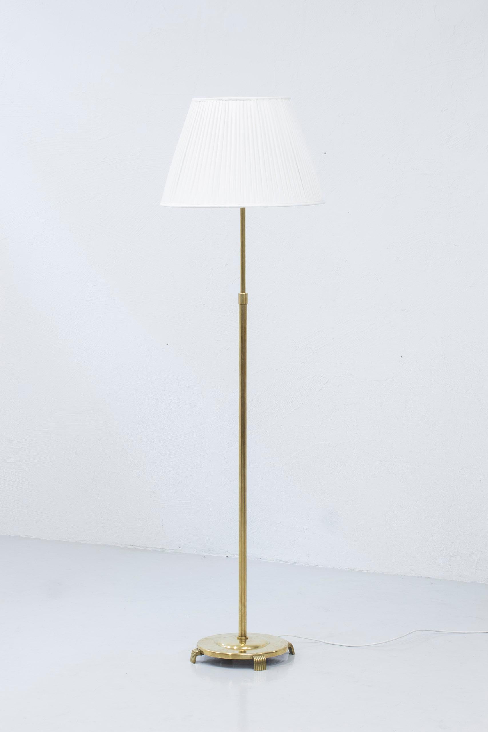 Floor lamp model 32753 produced by Nordiska Kompaniet. Attributed to the head designer for the NK lighting department Bertil Brisborg. Designed during the late 1930s and made ca 1930-40s. Made from brass, lacquered metal and leather. The shade is