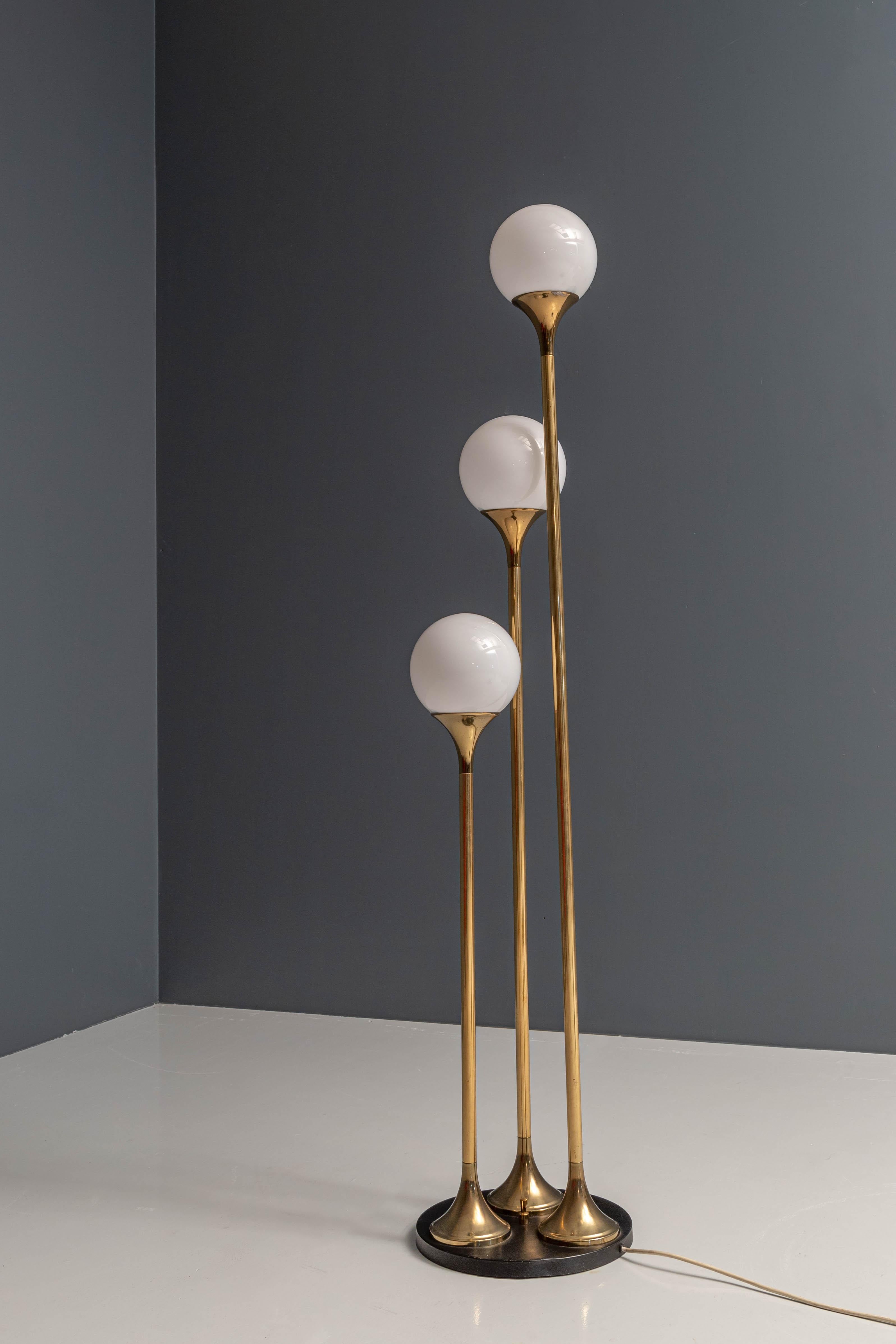 An elegant and smooth floor lamp from Italy. Good choice and mix of materials: brass, metal and white glass, creating the typical Italian ambiance of design and luxurious well thought over interiors.