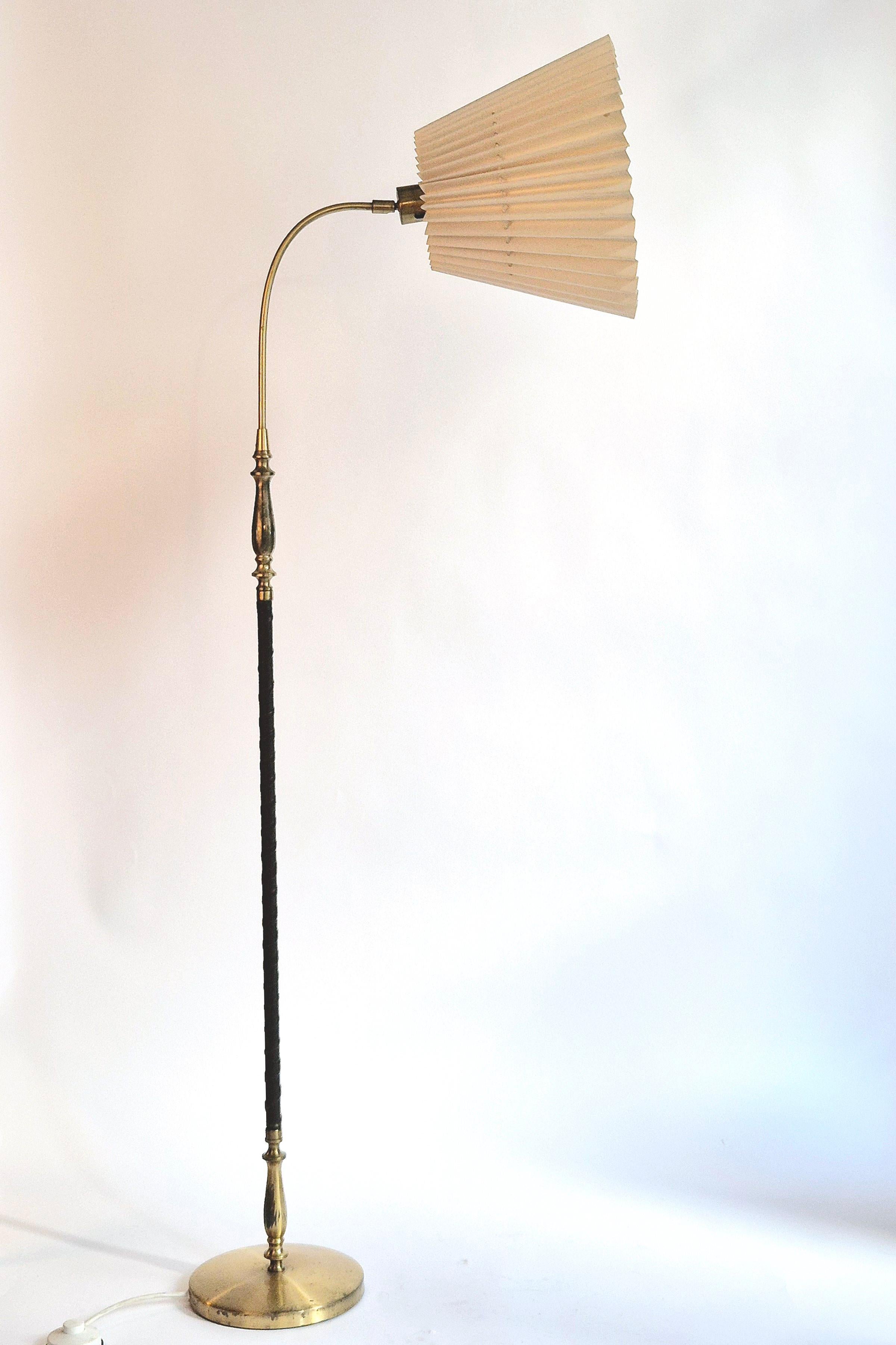 Una rara lampada da terra, modello 5737 di Einar Bäckström. Realizzato in ottone massiccio con finiture in pelle. Con marchio del produttore e numero di modello. 

Paralume originale con alcuni danni interni. Bella patina, normali segni di età e