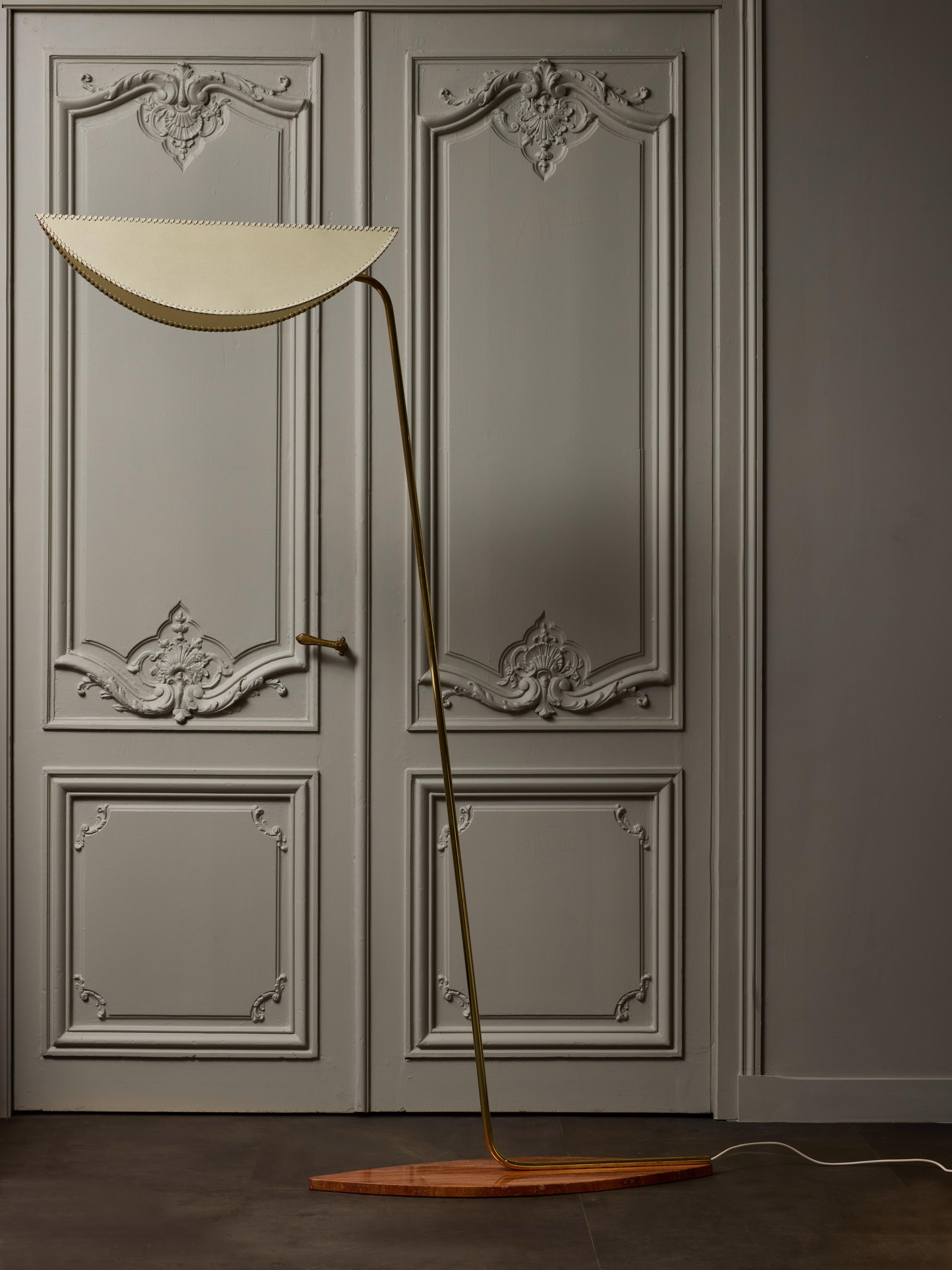 Elegante lampada da terra del designer italiano Diego Mardegan, questo pezzo è composto da una base in marmo sottile a forma di occhio di gatto, un braccio obliquo in ottone che sostiene un paralume personalizzato realizzato in carta e intrecciato a
