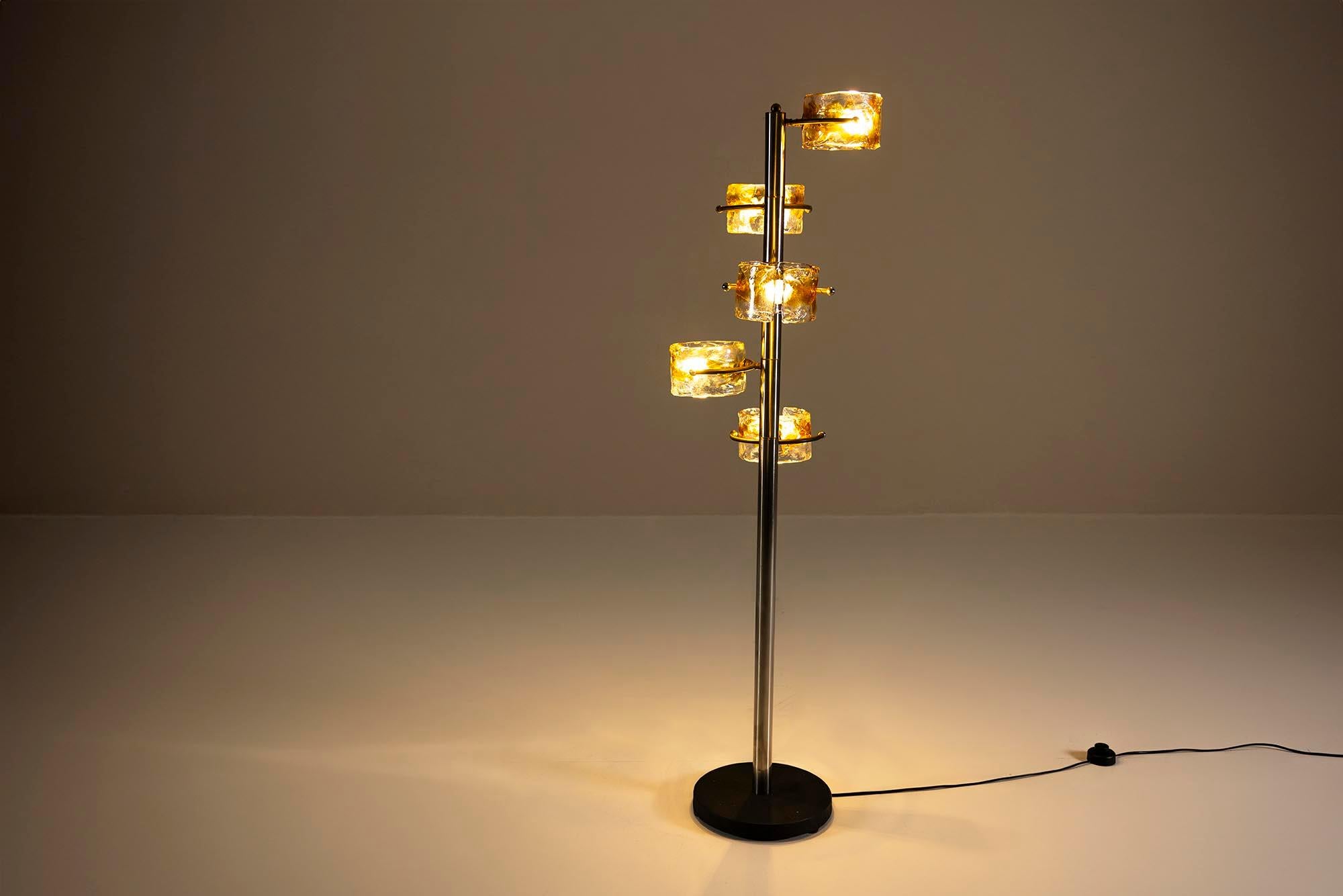This exquisite floor lamp, inspired by the style of Tony Zuccheri, is a harmonious blend of Murano glass artistry and sleek chromed metal.

Design
The lamp stands on a solid, round black base, providing stability and an elegant contrast to the