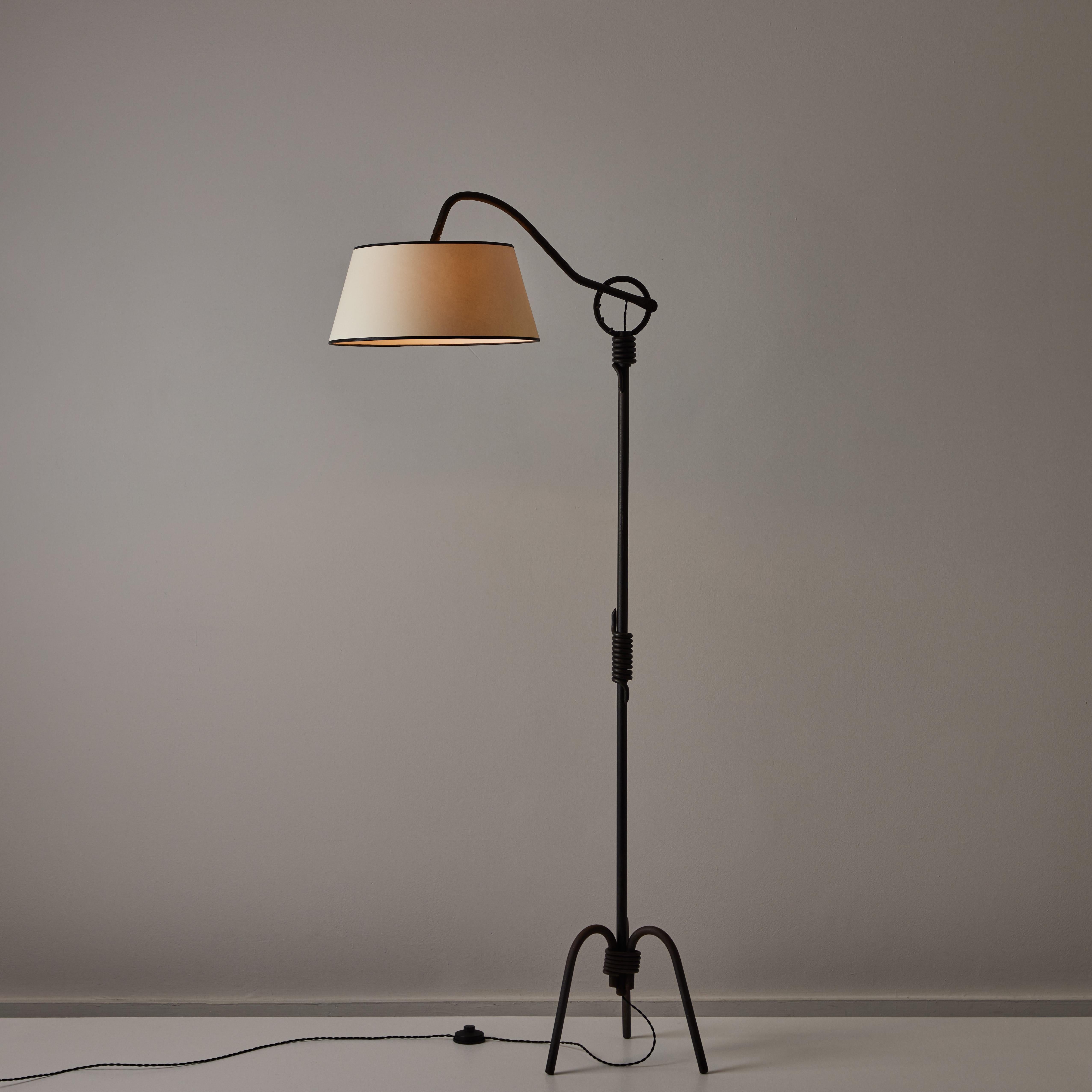 French Floor Lamp. Designed in France, in 1959. The floor lamp consists of a wrought iron base, featuring wrapped metal detail on the top, middle and bottom of the stem. The iron base consists of a three-footed tripod. The socket is an E27 socket,