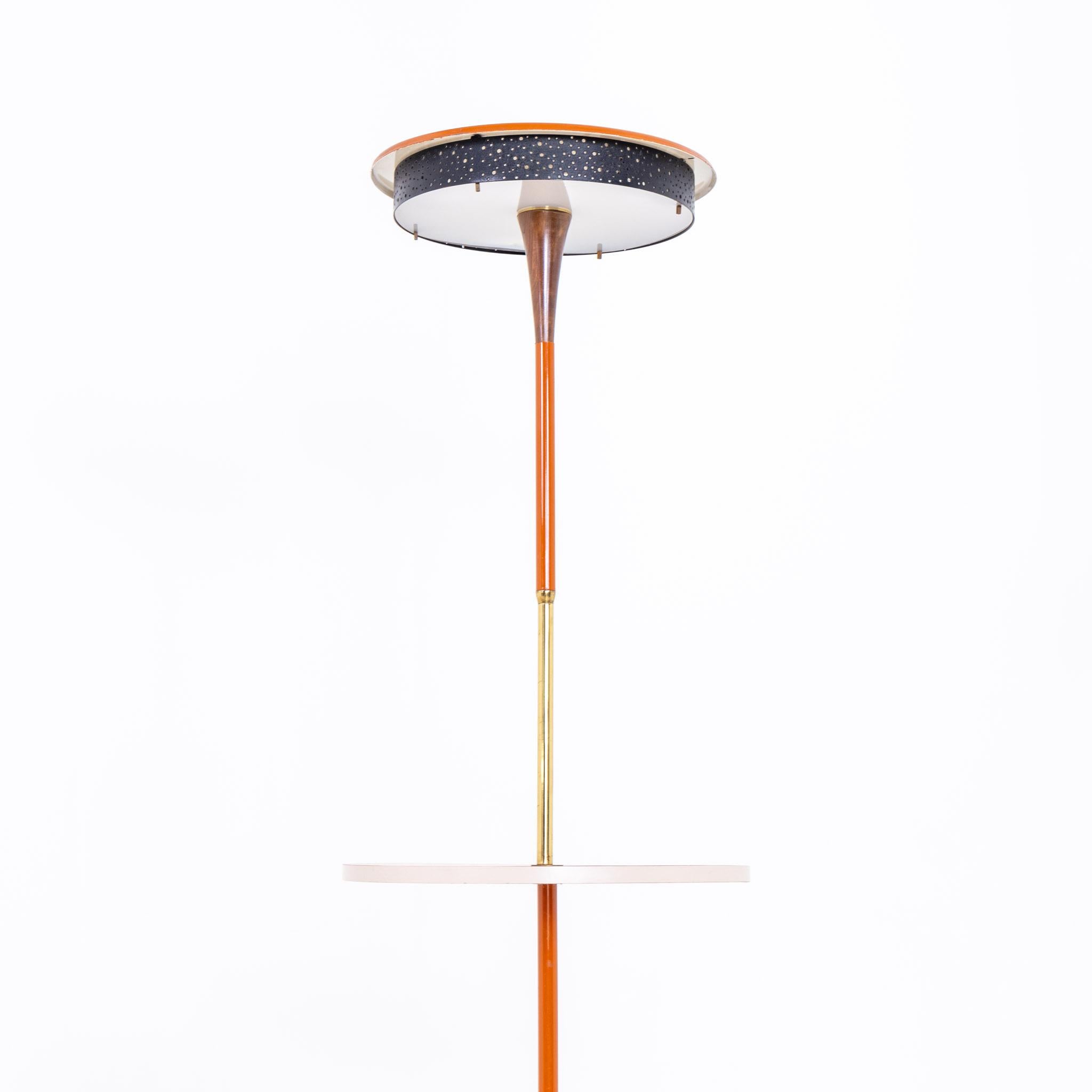 Floor lamp on disc base with central shelf and round lampshade. Wood, brass and metal, partially painted red.