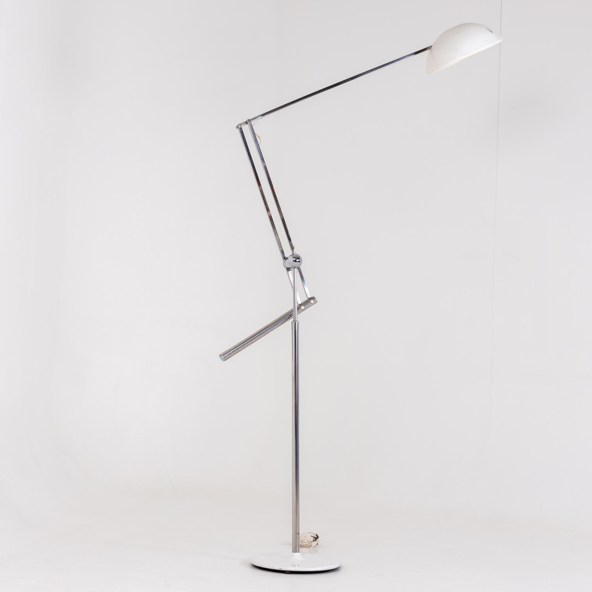 Floor lamp on round base with chrome frame and white lampshade. Signs of age and use.