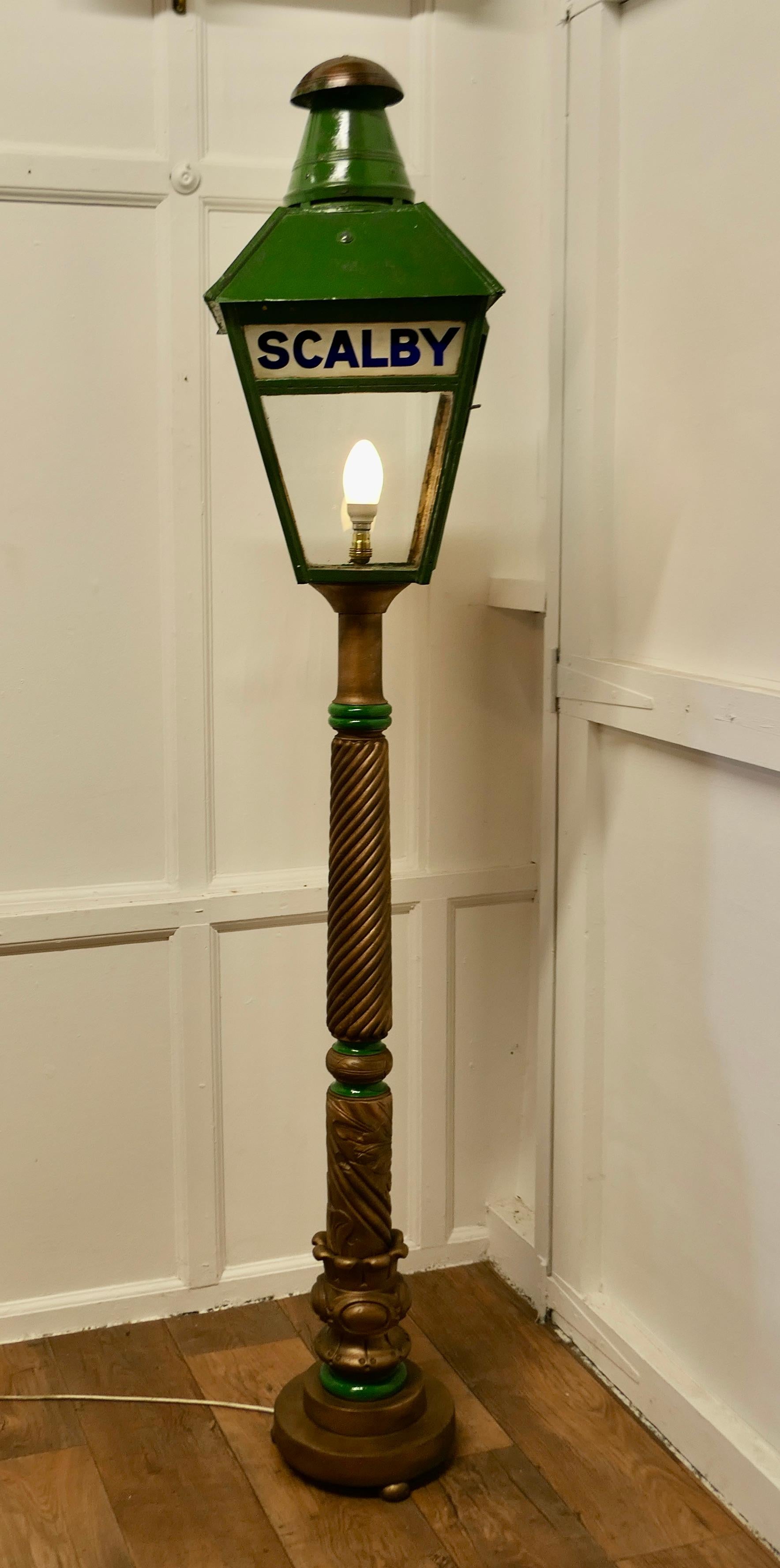 Floor Lamp Lantern from Scalby Station N.E.R. set on a Column

A Lovely looking piece, the top of the lamp is original with SCALBY in the glass at the top of one side only, the lamp is in green with a copper heat deflector
The Lantern has been set
