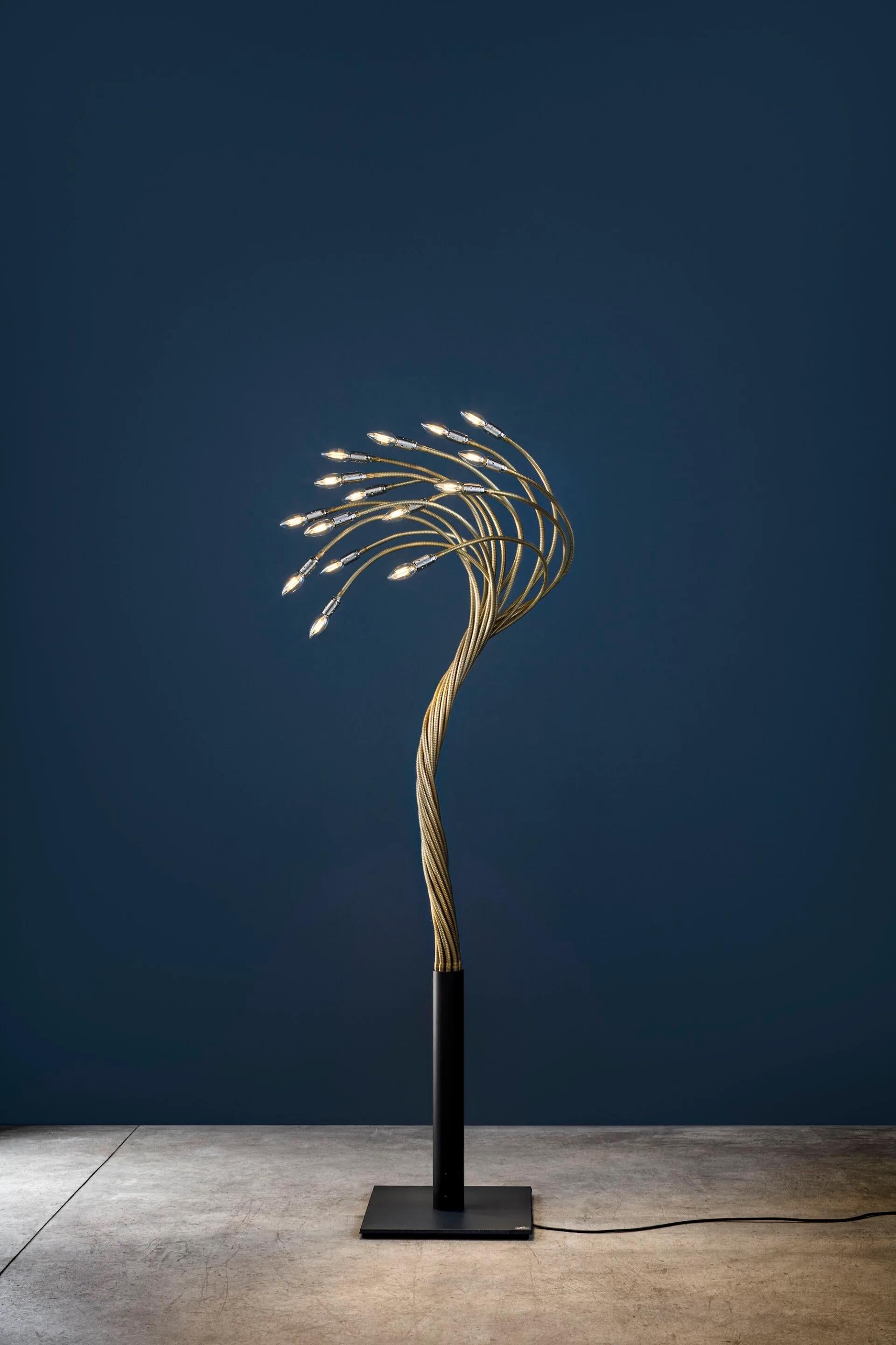 La Sottovento, de la serie Turciù de Catellani & Smith, es una lámpara de pie flexible diseñada para interactuar con su entorno. Su nombre refleja la capacidad de girar y dar forma a los brazos flexibles de la lámpara según se desee, creando una