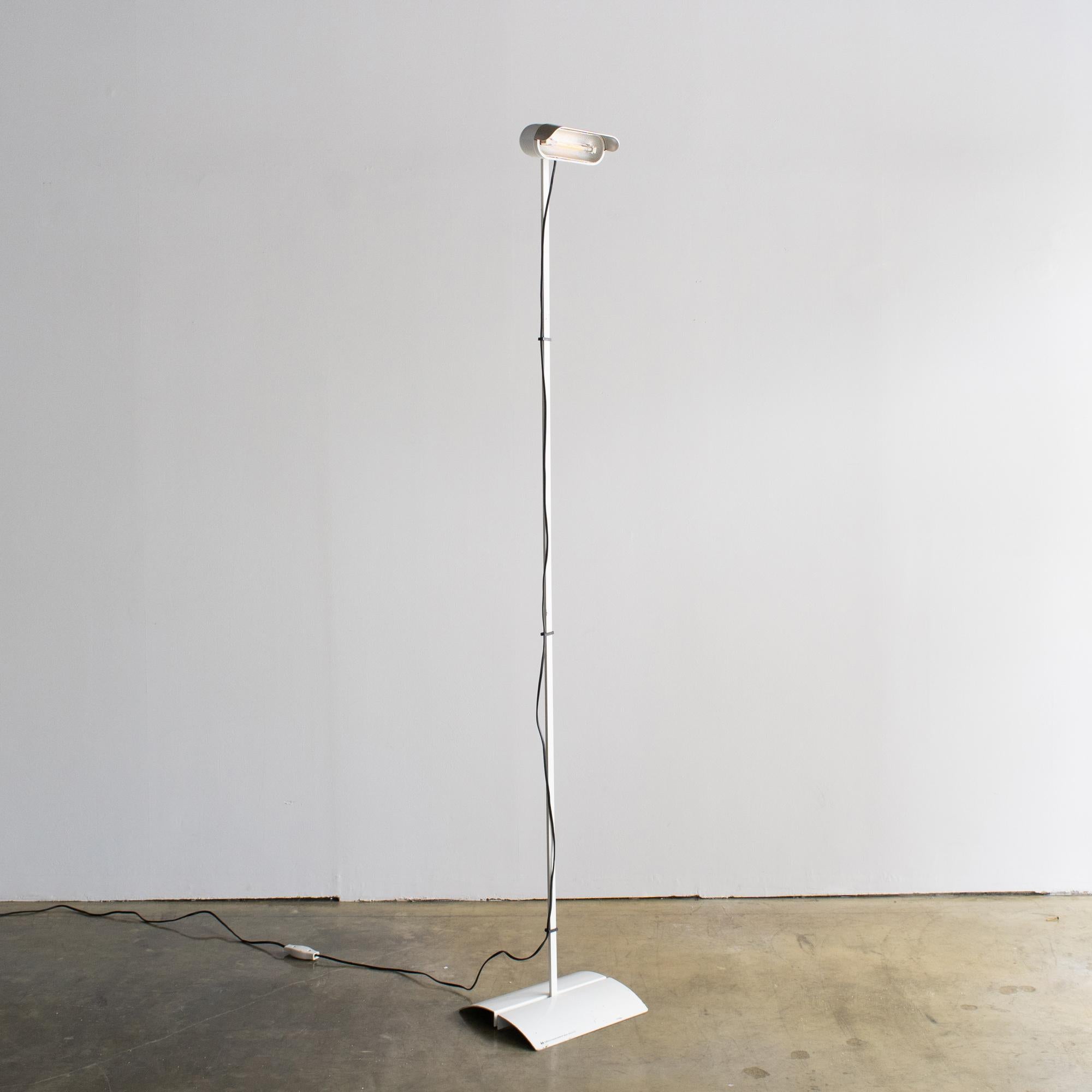 Lampada da terra progettata da STD per Luci. Progettato e pubblicato probabilmente alla fine degli anni '70 o all'inizio degli anni '80. Carrozzeria verniciata di bianco.  Il paralume è realizzato in plastica e acciaio. 
L'ombra può essere inclinata