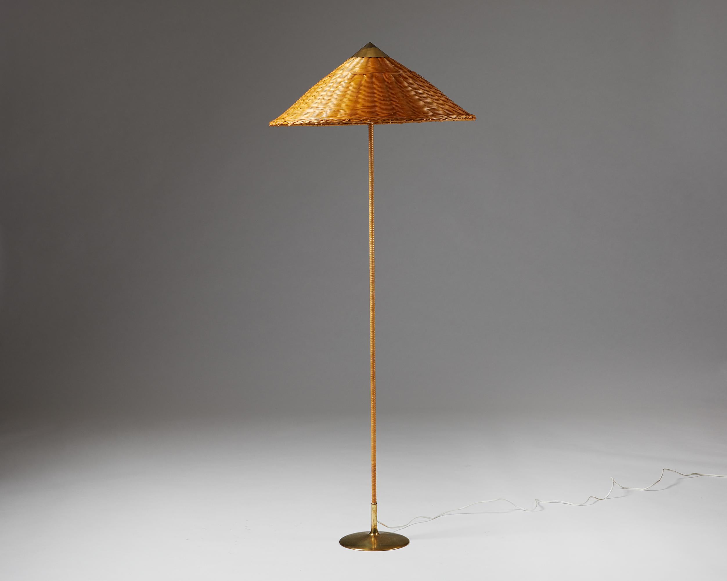 Brass and wicker shade. 

Measures: Height: 157 cm / 5’ 1 3/4’’
Diameter: 63 cm / 2 3/4’’.
 
