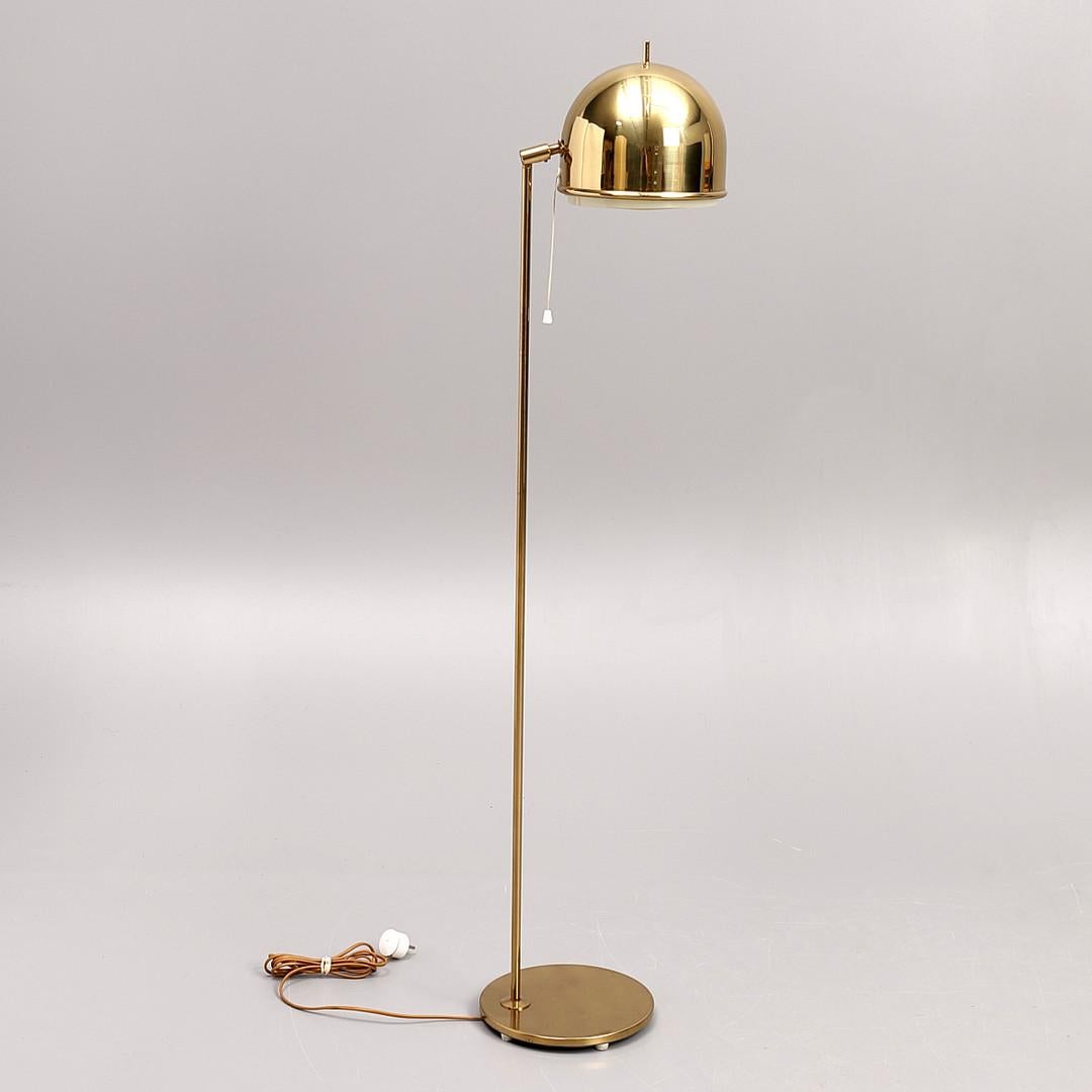 This floor lamp with fully adjustable shade was manufactured in brass by Bergboms and designed by Eje Ahlgren. The protruding brass rod at the top of the shade is intended to be used as a simple but effective way of moving the shade position from