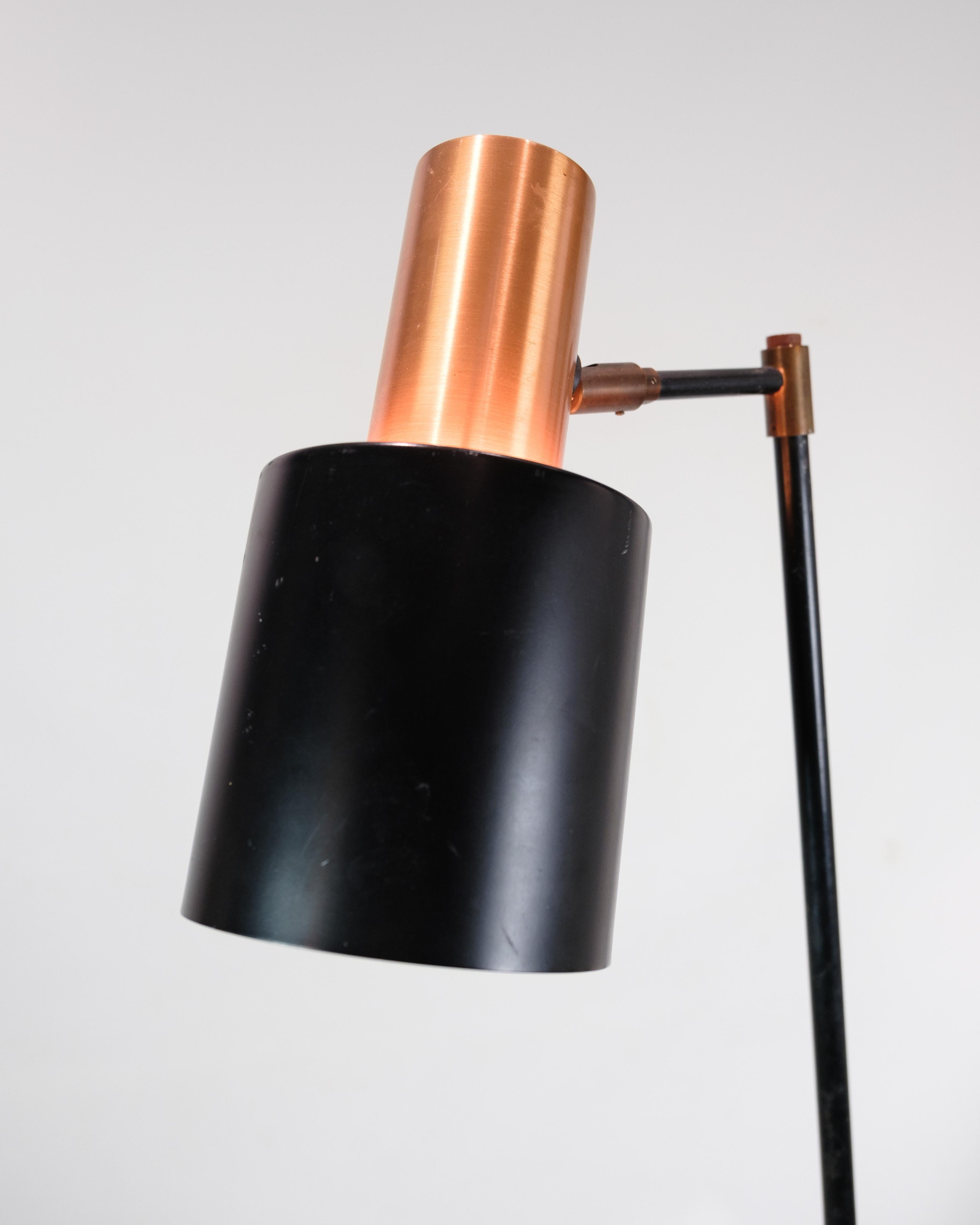Ce lampadaire, connu sous le nom de Design/One, est un bel exemple du design d'éclairage danois des années 1970. La lampe est dotée d'une tige en métal laqué noir et d'une base de couleur cuivre qui ajoute une touche d'élégance et de chaleur à tout
