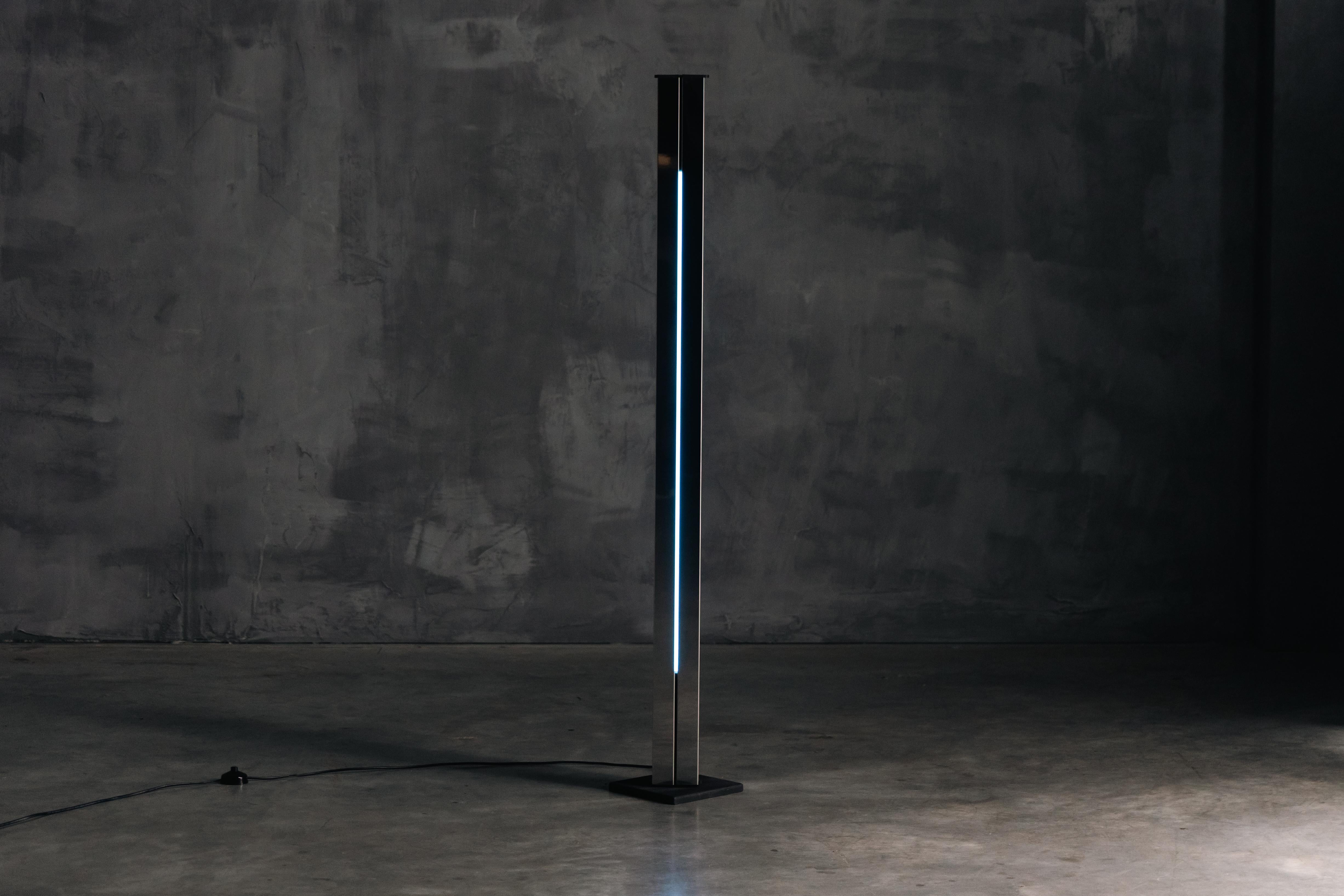 Lampada da terra Moonlight modello 14104 di Ettore Sottsass, realizzata negli anni '70 per Arredoluce. Questa lampada di grande impatto presenta un mix di acciaio inossidabile cromato, metallo laccato e neon, incarnando l'estetica d'avanguardia di