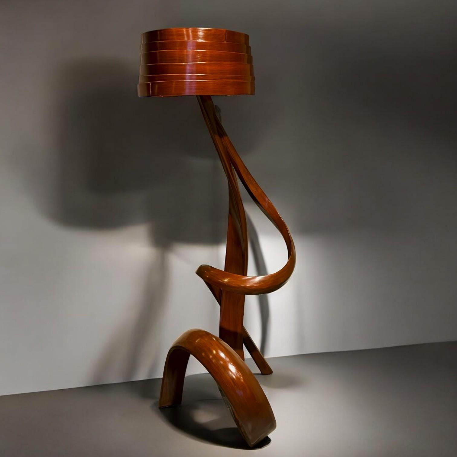 This piece is the Floor Lamp No. 1 - Fluentum Series.

The lamp is made by bending strips of ash wood, which is then sculpted to give details to the piece in order to maintain a harmonious design language throughout the piece. The lampshade is also