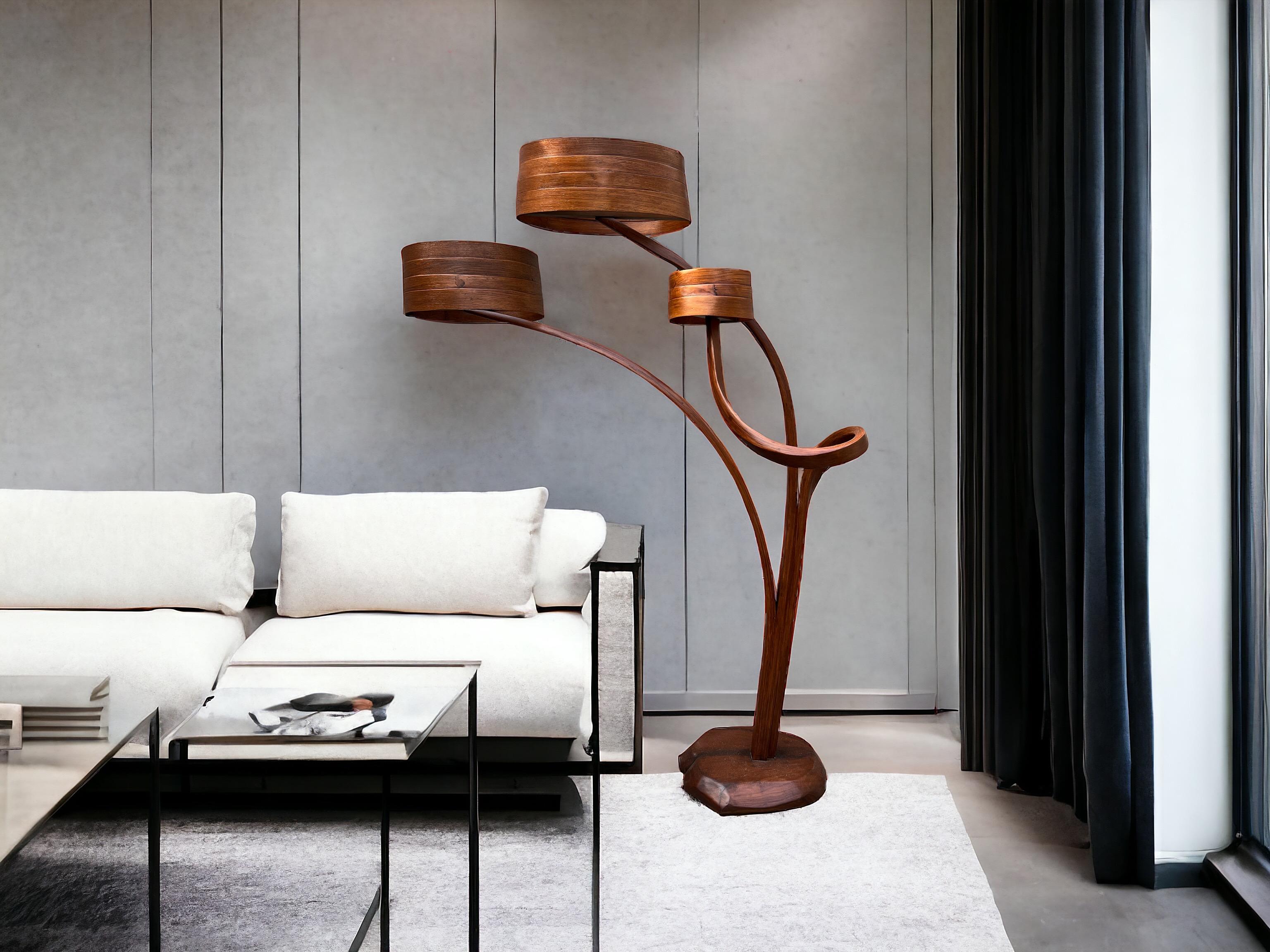 A lighting piece crafted by hand; the piece stems from the base and flows to have three lighting sources, at different levels. All of the lamp shades are different from the other in  size; which illuminate the piece and the space around it in a