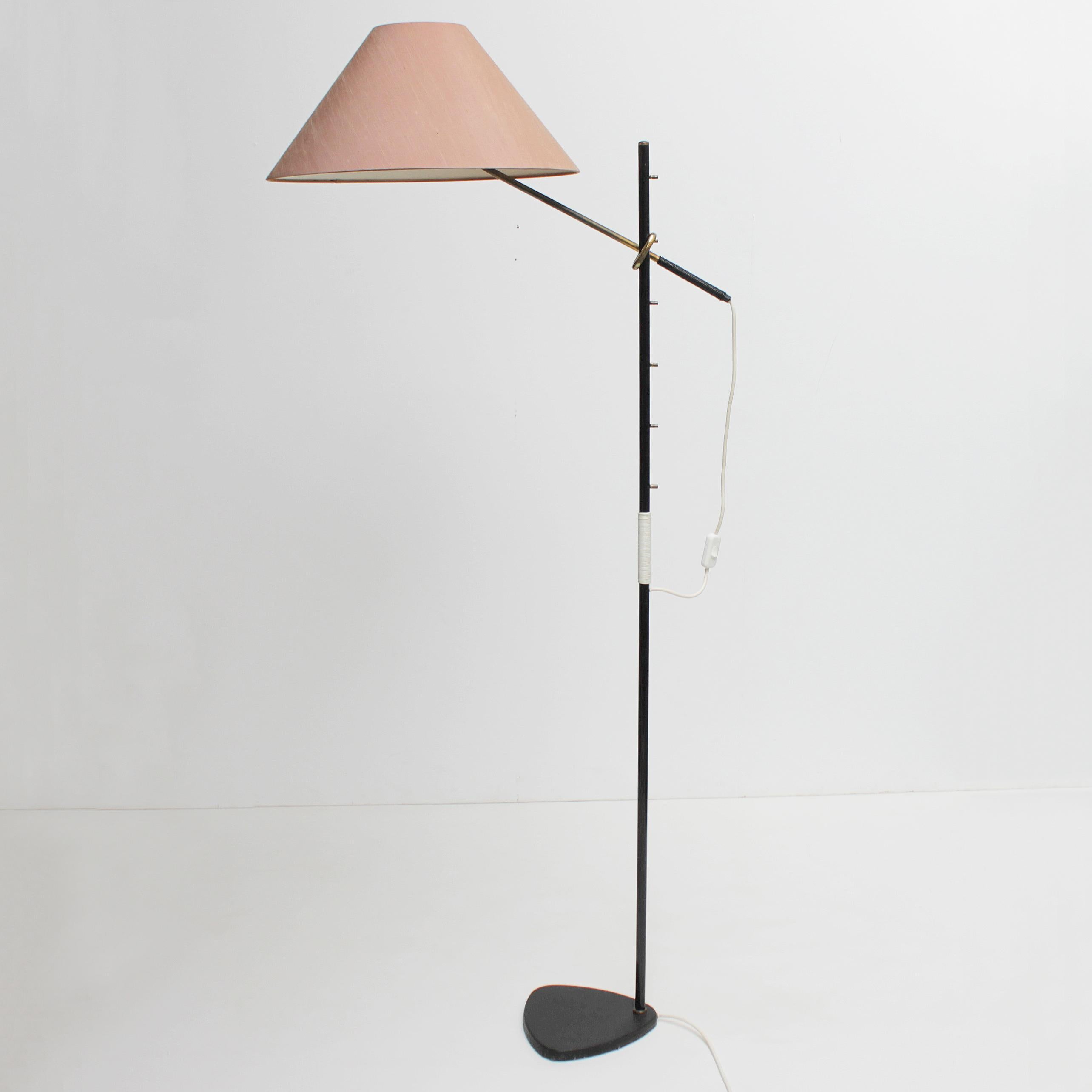 Floor lamp model 'Pelikan' No. 2097 by J.T. Kalmar, Vienna Austria.
Black lacquered cast base and stem with brass details. The taupe shade on the brass arm is adjustable in six positions. Wear consistent with age and use, minor scratches and lost
