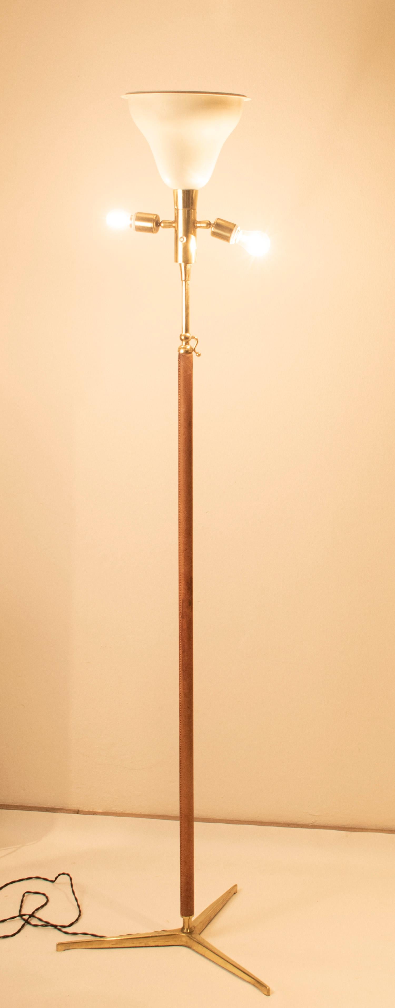 Lampada da terra attribuita a Gino Sarfatti con stelo tubolare regolabile in ottone lucido avvolto in pelle marrone. Paravento originale in tessuto, anni '50.
Diametro 47 cm.
Misure: Altezza minima 170 cm.
Altezza massima 220 cm
Spina europea (fino